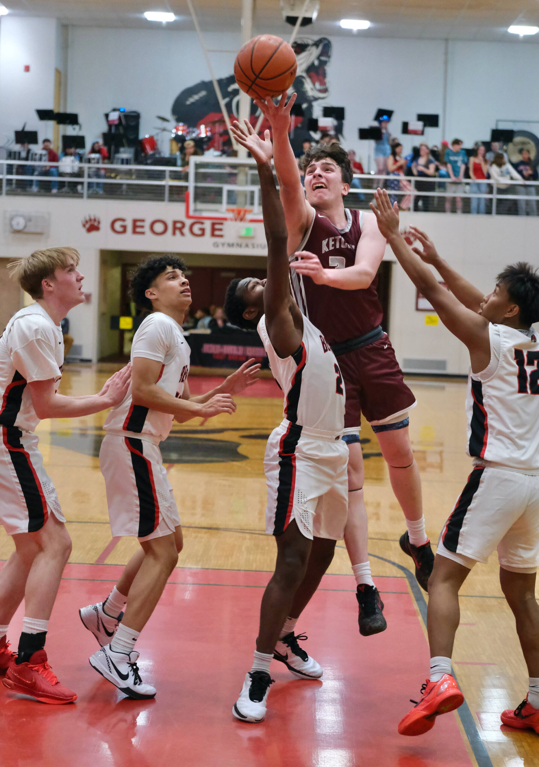 Ketchikan senior Marcus Stockhausen scores against Juneau-Douglas High School: Yadaa.at Kalé senior Ahmir Parker (2) and junior Joren Gasga (12) as JDHS seniors Ben Sikes and Pedrin Saceda-Hurt look on during the Kings 52-48 win over the Crimson Bears on Friday at the George Houston Gymnasium in Juneau. (Klas Stolpe / Juneau Empire)