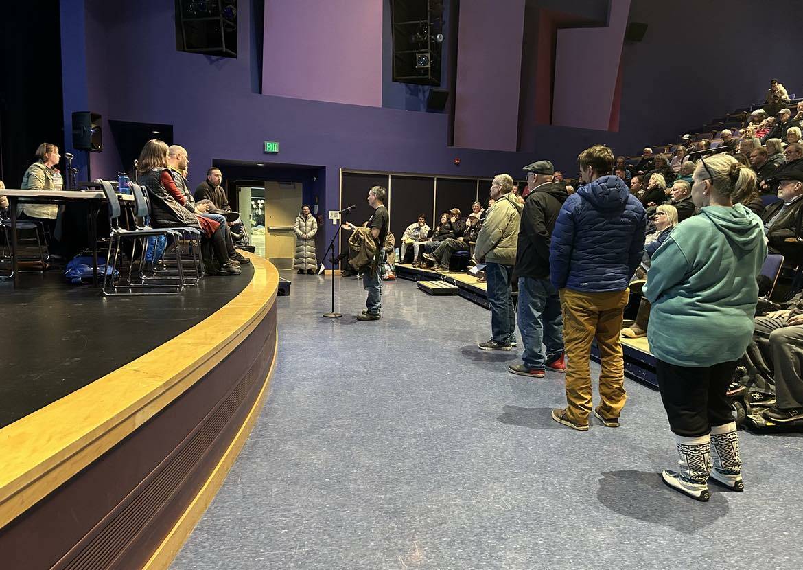 Juneau residents line up in the Thunder Mountain Middle School auditorium on Friday to ask questions and protest the HESCO flood barriers that are potentially being installed this summer. (Jasz Garrett / Juneau Empire)