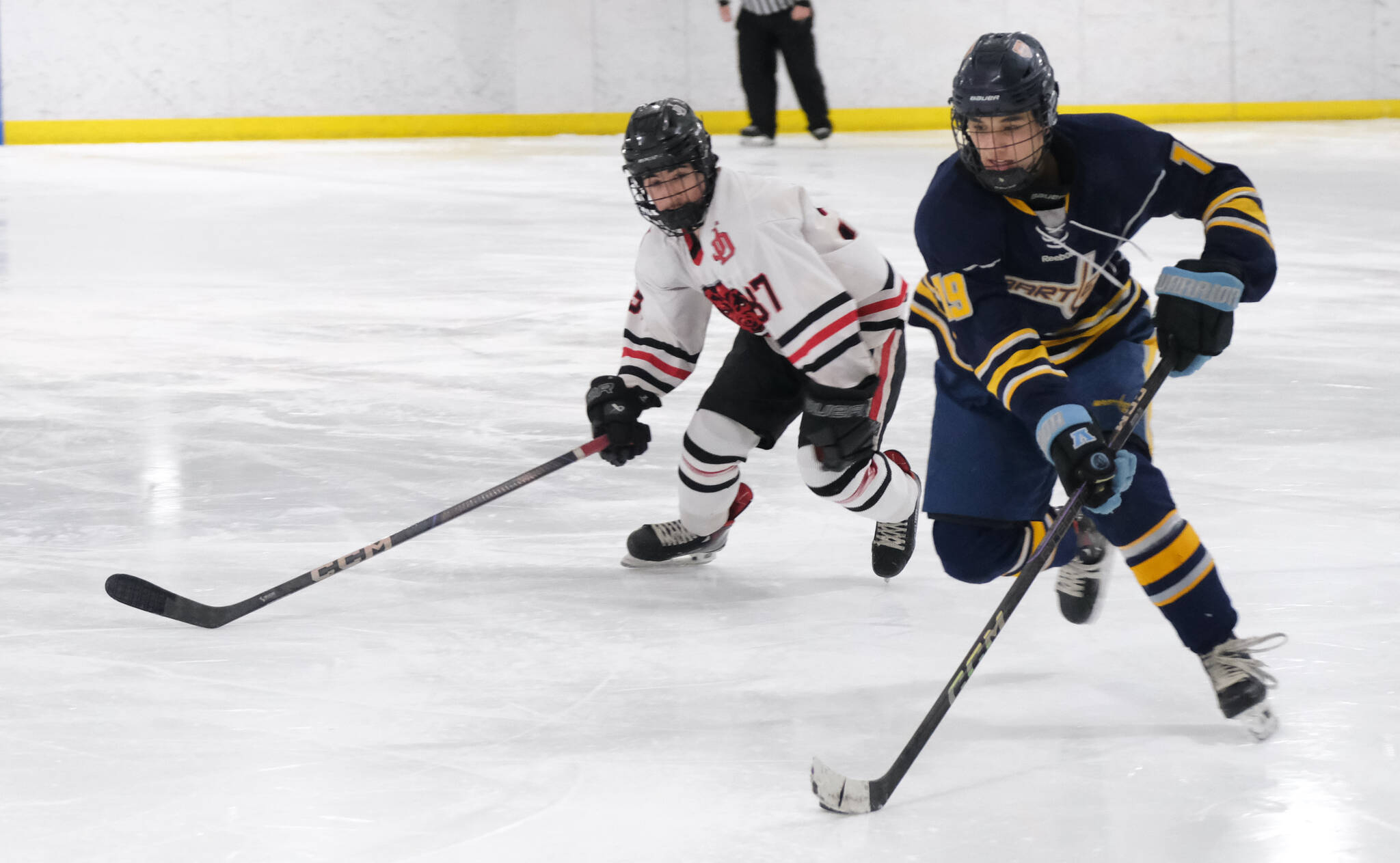 Juneau-Douglas High School: Yadaa.at Kalé senior Emilio Holbrook (37) defends Bartlett senior Dylan Beals (19) during the Crimson Bears’ 10-6 win over the Golden Bears on Saturday at Treadwell Ice Arena. (Klas Stolpe / Juneau Empire)