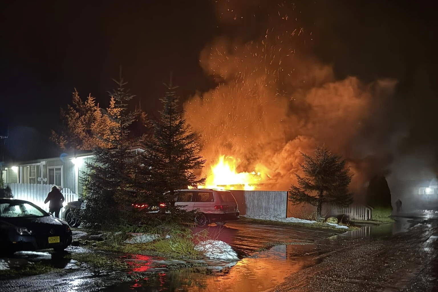 A trailer in the Sprucewood Park mobile home neighborhood burns on Monday night. Fire officials said the trailer apparently has long been unoccupied. (Photo by Gerald Mayeda)