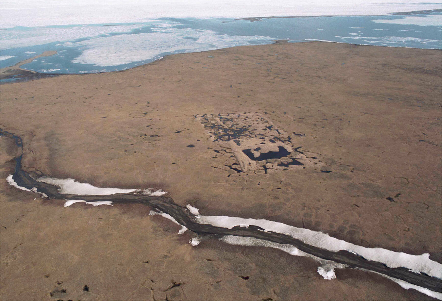 An aerial shows the footprint of the test well drilled in the mid-1980s on land owned by the Kaktovik Native village corporation within the 1002 area of the Arctic National Wildlife Refuge. (Michael Penn / Juneau Empire file photo)