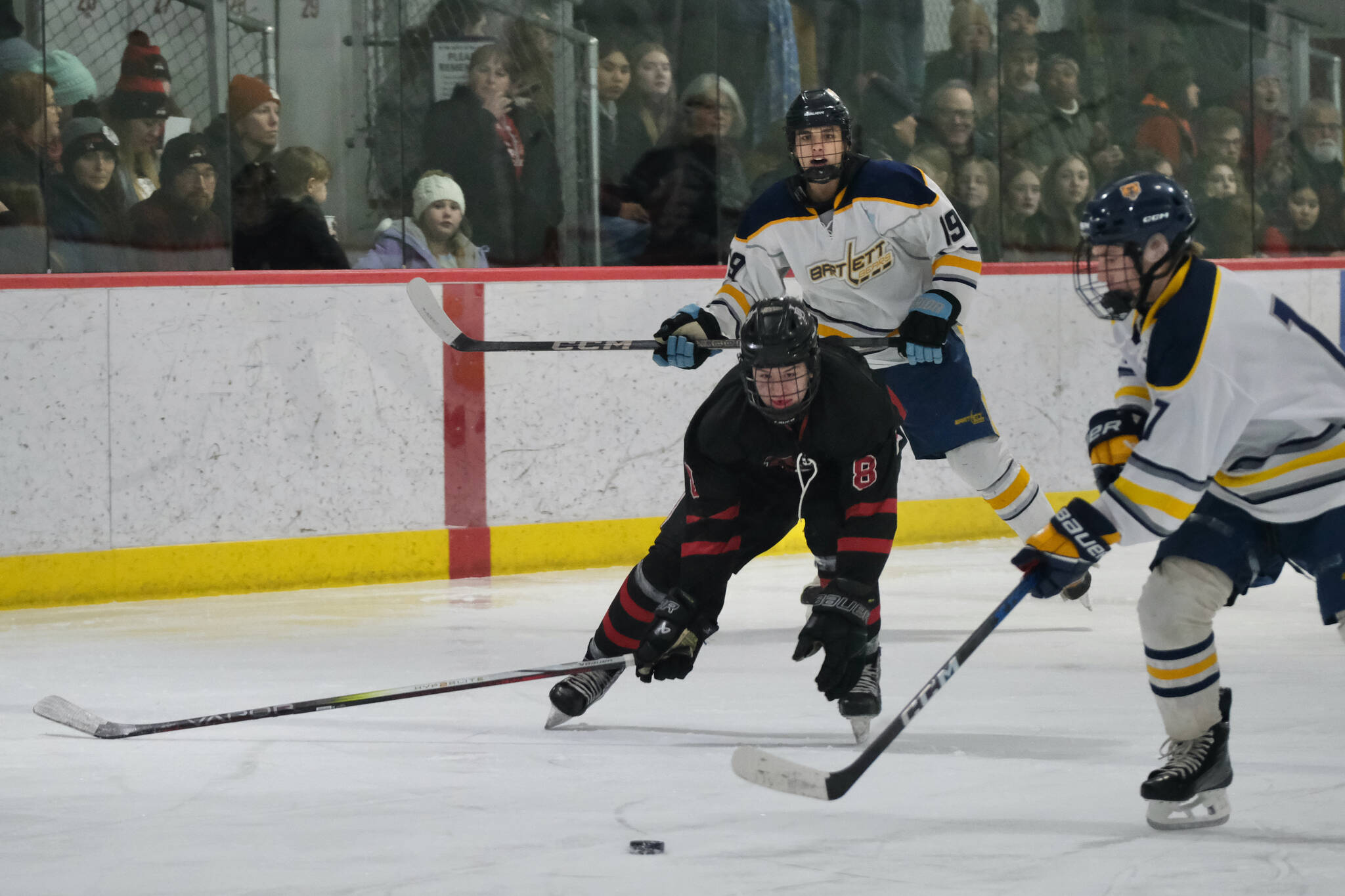 Juneau-Douglas High School: Yadaa.at Kalé senior Zander Smith (8) works for a puck against Bartlett in last Saturday’s 10-6 Crimson Bears win over the Golden Bears at Juneau’s Treadwell Ice Arena. Smith was voted a player of the match against Houston in Thursday’s Crimson Bears win over the Hawks. (Klas Stolpe / Juneau Empire file photo)