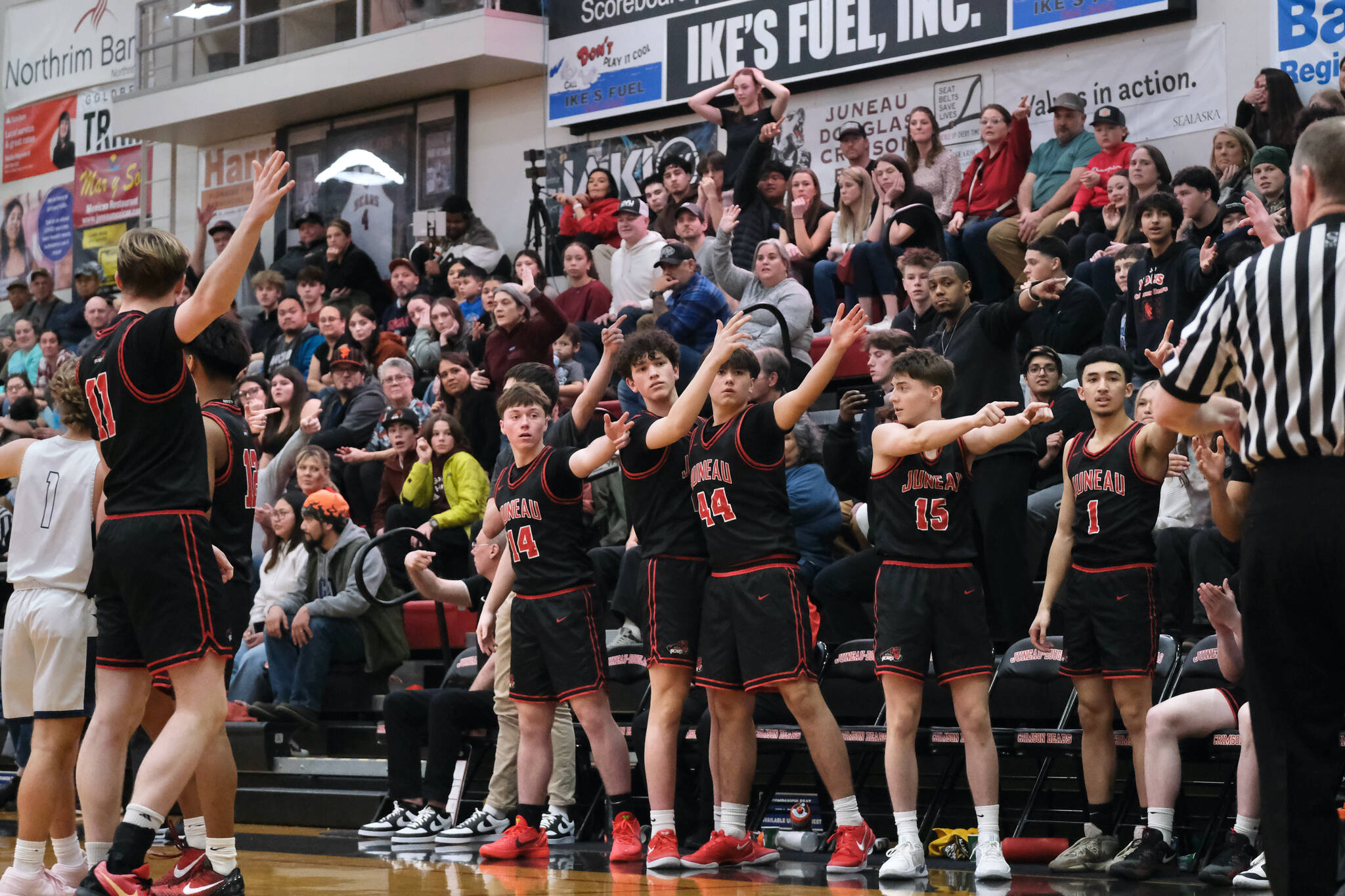 Players on the Juneau-Douglas High School: Yadaa.at Kalé bench earlier this season help the referees with a call against Soldotna in the George Houston Gymnasium. The Crimson Bears fell to Monroe on Friday 84-71 in the Colony Basketball Classic at Palmer. (Klas Stolpe / Juneau Empire file photo)