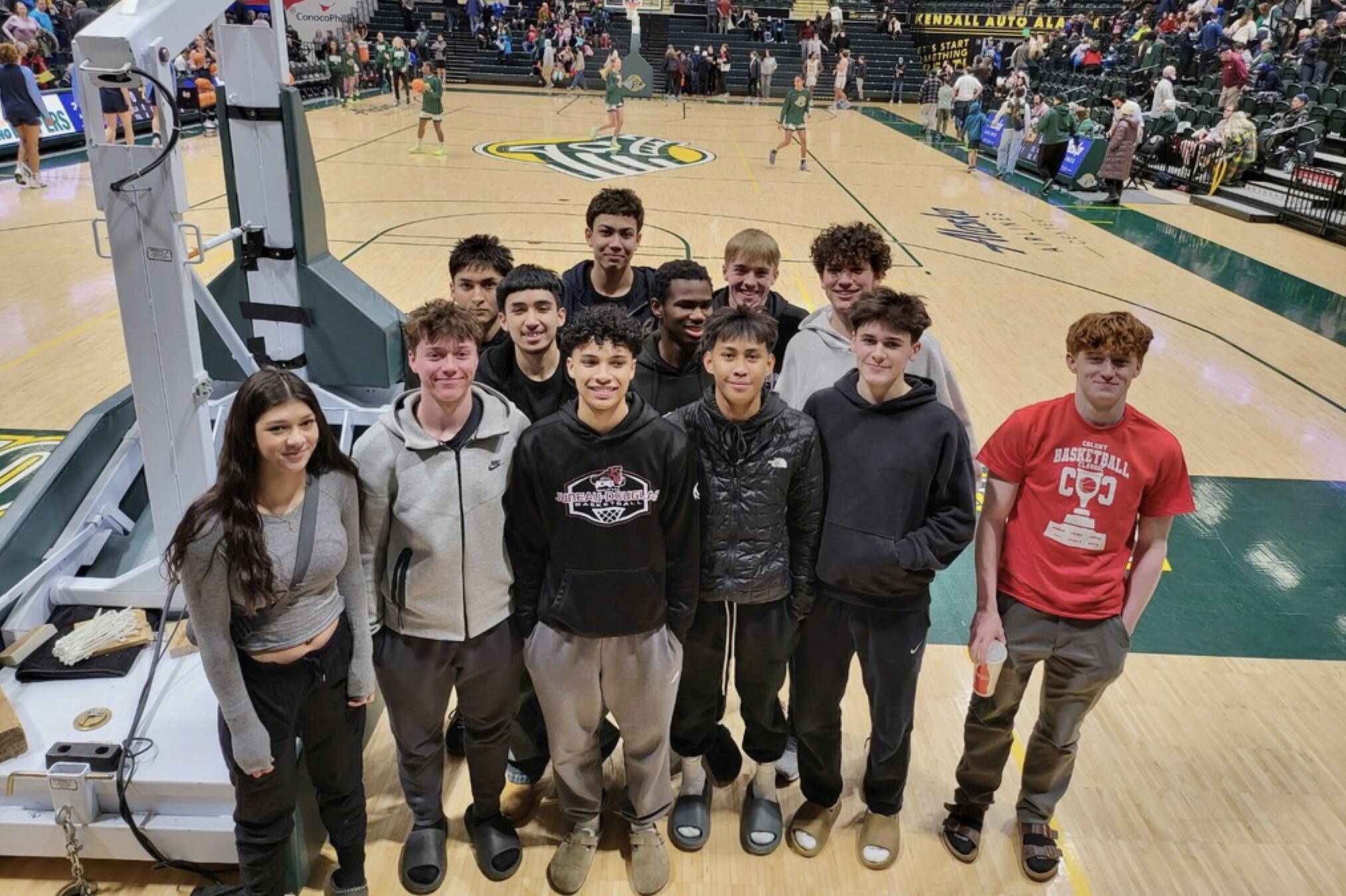 The Juneau-Douglas High School: Yadaa.at Kalé Crimson Bears boys basketball team pose at Anchorage’s Alaska Airlines Center on Saturday after watching a college game. Earlier in the day JDHS finished their final Colony Basketball Classic tournament game in Palmer, losing to Bettye Davis East Anchorage High School 71-54. (Photo courtesy JDHS)