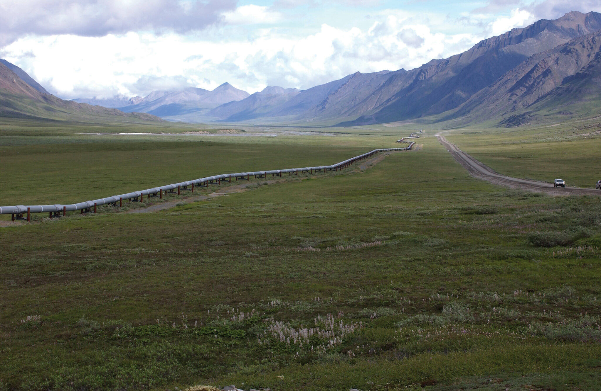 A view of the Trans-Alaska Pipeline, from the northern Brooks Range. The rocks in the background produce oil on the North Slope. (Dave Houseknecht, U.S. Geological Survey)