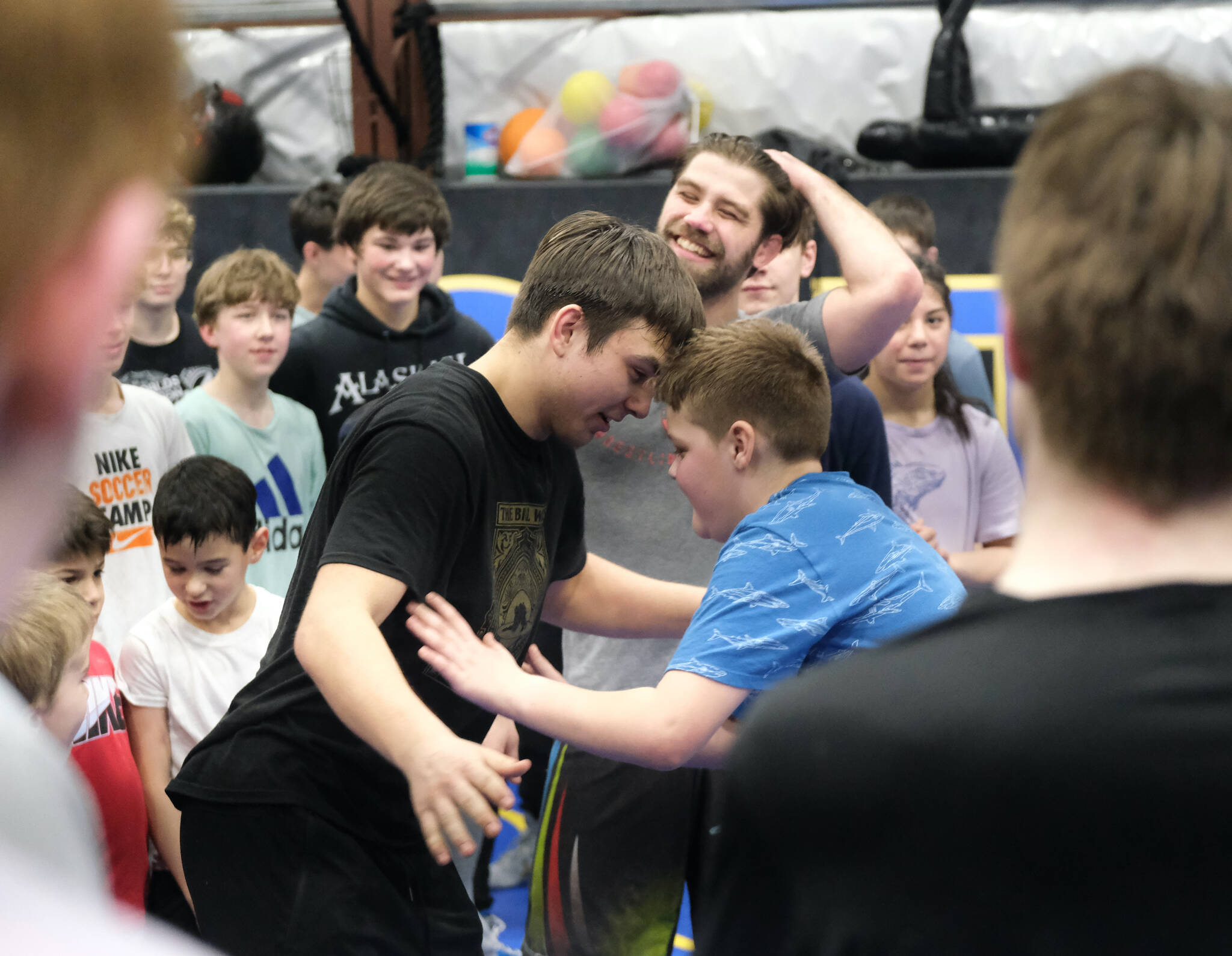 Juneau-Douglas High School: Yadaa.at Kalé junior Alex Marx-Beierly and Auke Bay Elementary School sixth-grader Steven Fairchild try a balance game as teammates and Askren Wrestling Academy coach Wilder Wichman looks on Sunday during a three-day wrestling clinic at the Juneau Wrestling Center. (Klas Stolpe / Juneau Empire)