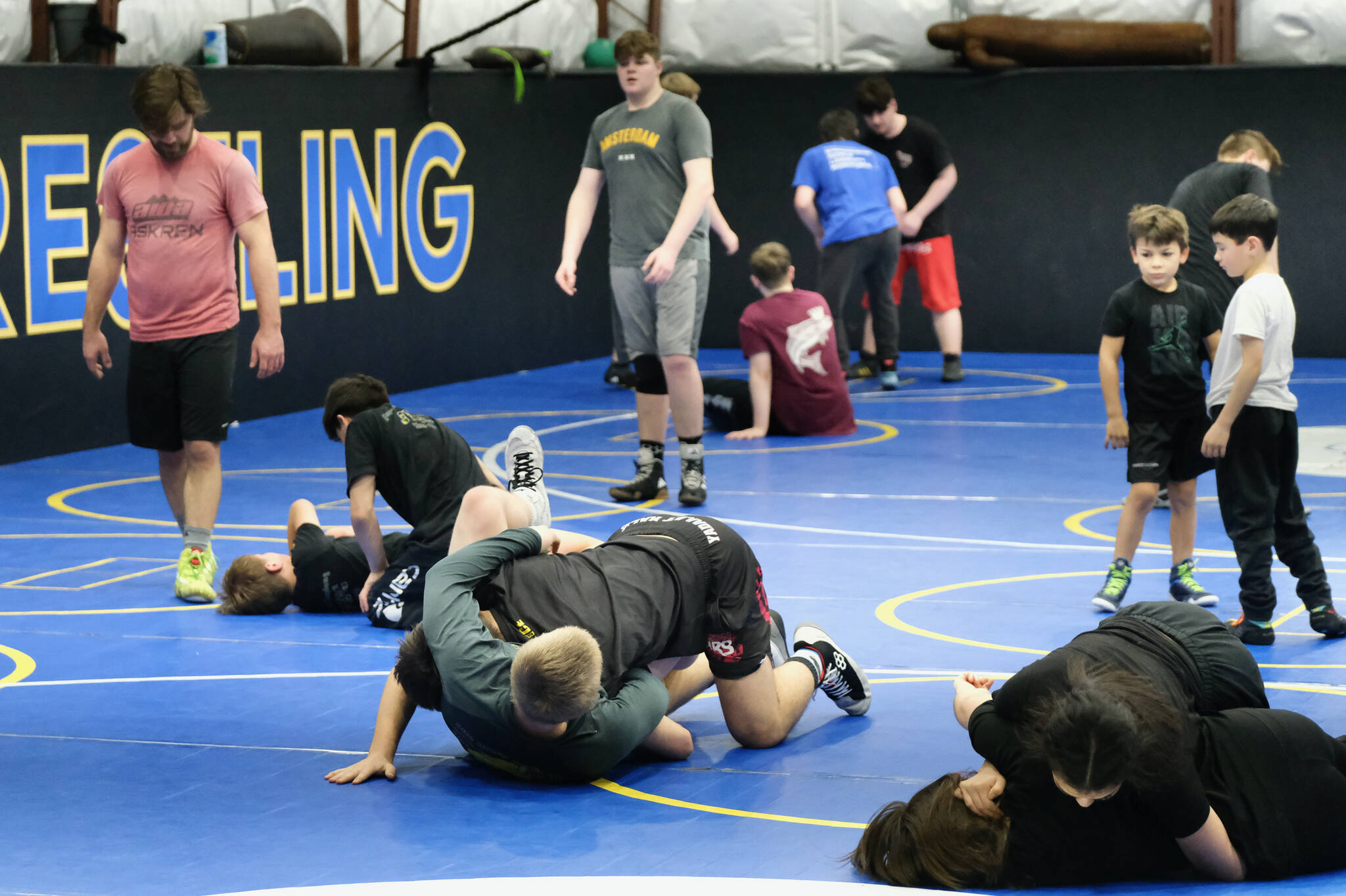 Askren Wrestling Academy coach Wilder Wichman watches as grapplers work techniques on Monday during a three-day wrestling clinic at the Juneau Wrestling Center. (Klas Stolpe / Juneau Empire)