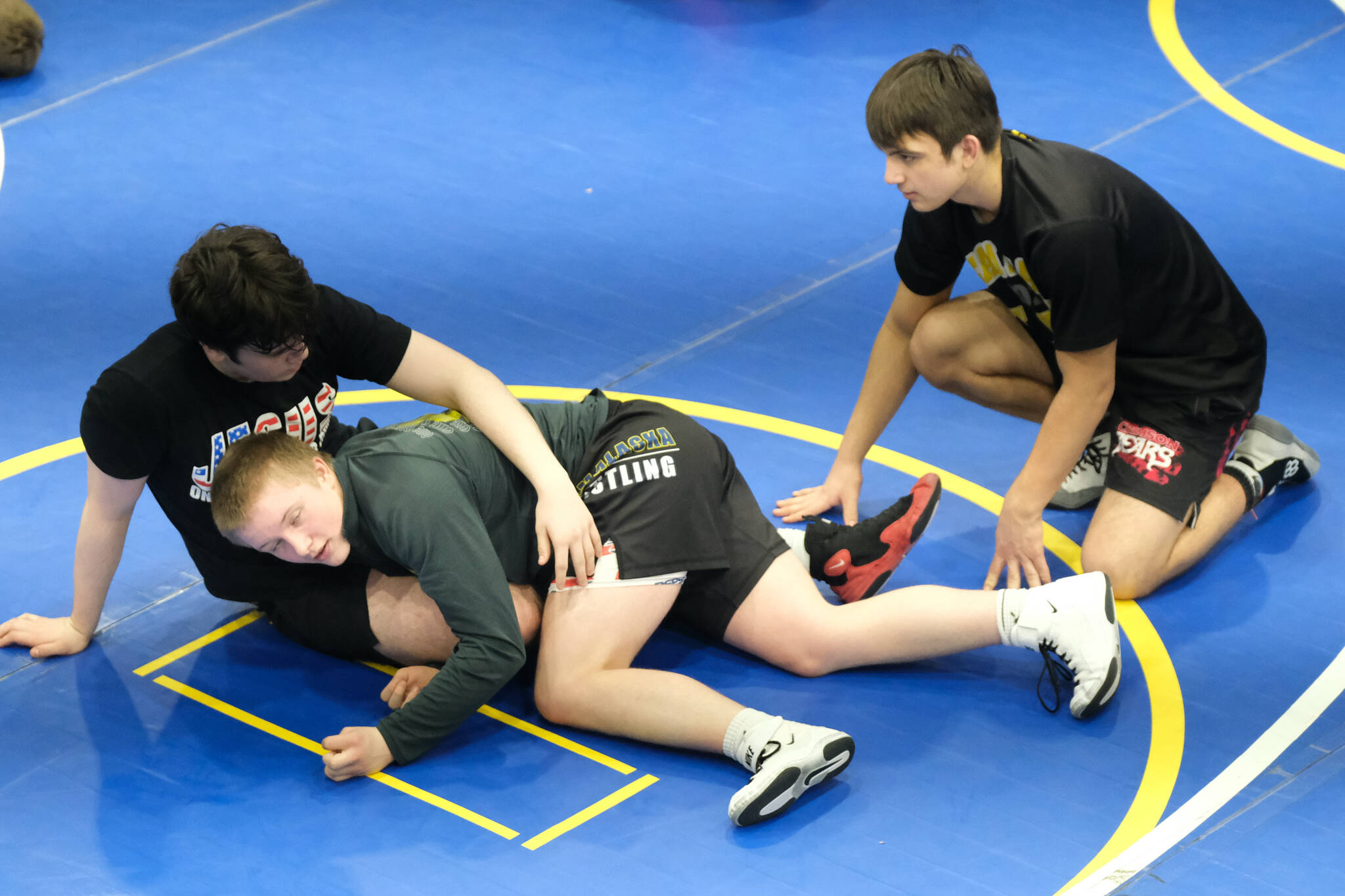 Juneau-Douglas High School: Yadaa.at Kalé sophomore William Dapcevich, freshman Ivan Shockley and junior Alex Marx-Beierly work on a technique Monday during a three-day wrestling clinic at the Juneau Wrestling Center led by Askren Wrestling Academy coach Wilder Wichman. (Klas Stolpe / Juneau Empire)