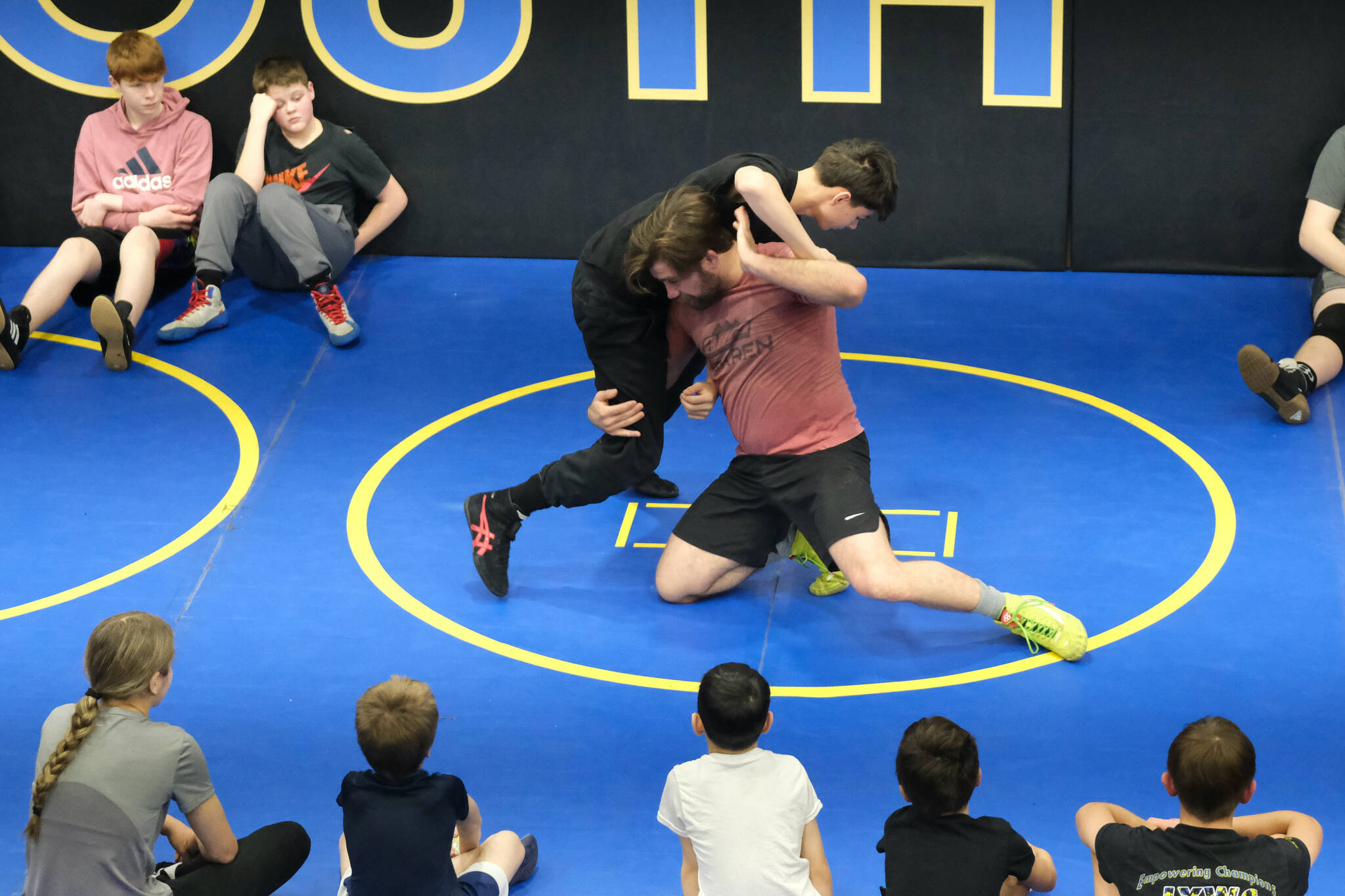 Askren Wrestling Academy coach Wilder Wichman demonstrates a technique against Juneau-Douglas High School: Yadaa.at Kalé sophomore Landyn Dunn on Monday during a three-day wrestling clinic at the Juneau Wrestling Center. (Klas Stolpe / Juneau Empire)