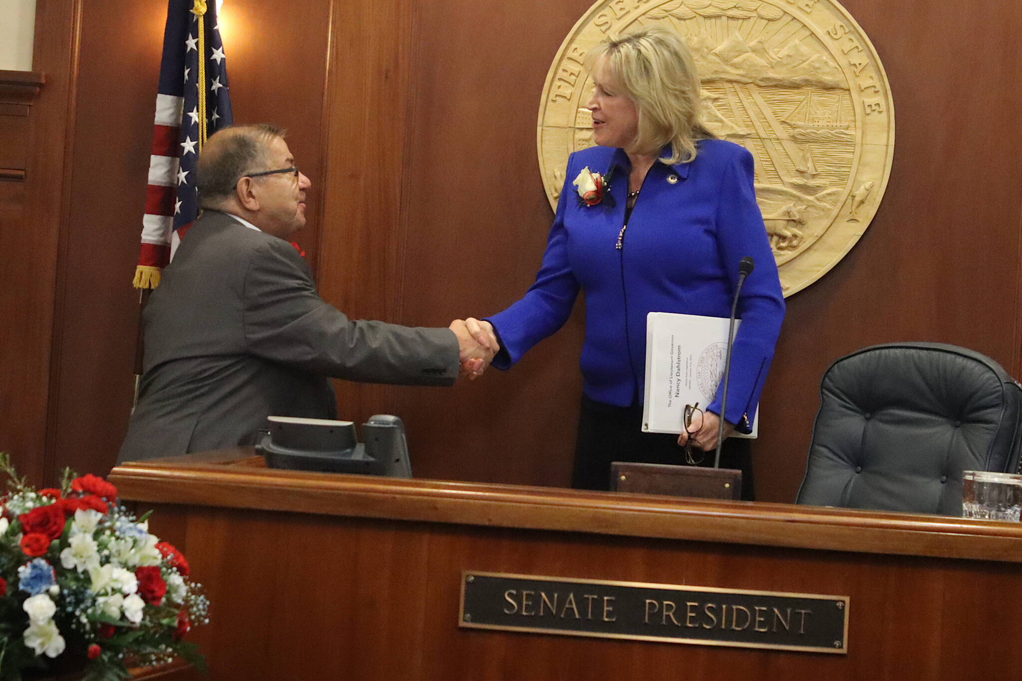 Lt. Gov. Nancy Dahlstrom greets Sen. Lyman Hoffman (D-Bethel) as he fulfils the role of president pro tempore of the state Senate during the opening day of the 34th Alaska State Legislature on Tuesday. Hoffman fulfilled the ceremonial role briefly until Sen. Gary Stevens (R-Kodiak) was unanimously elected Senate President. (Mark Sabbatini / Juneau Empire)