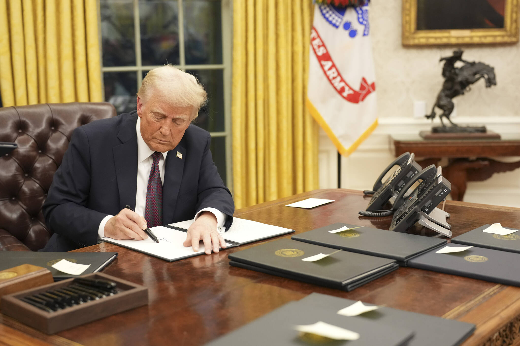 President Donald Trump signs executive orders in the Oval Office of the White House in Washington on Monday, Jan. 20, 2025, following his inauguration as the 47th president. Legal experts said the president was testing the boundaries of executive power with aggressive orders designed to stop the country from transitioning to renewable energy. (Doug Mills/The New York Times)