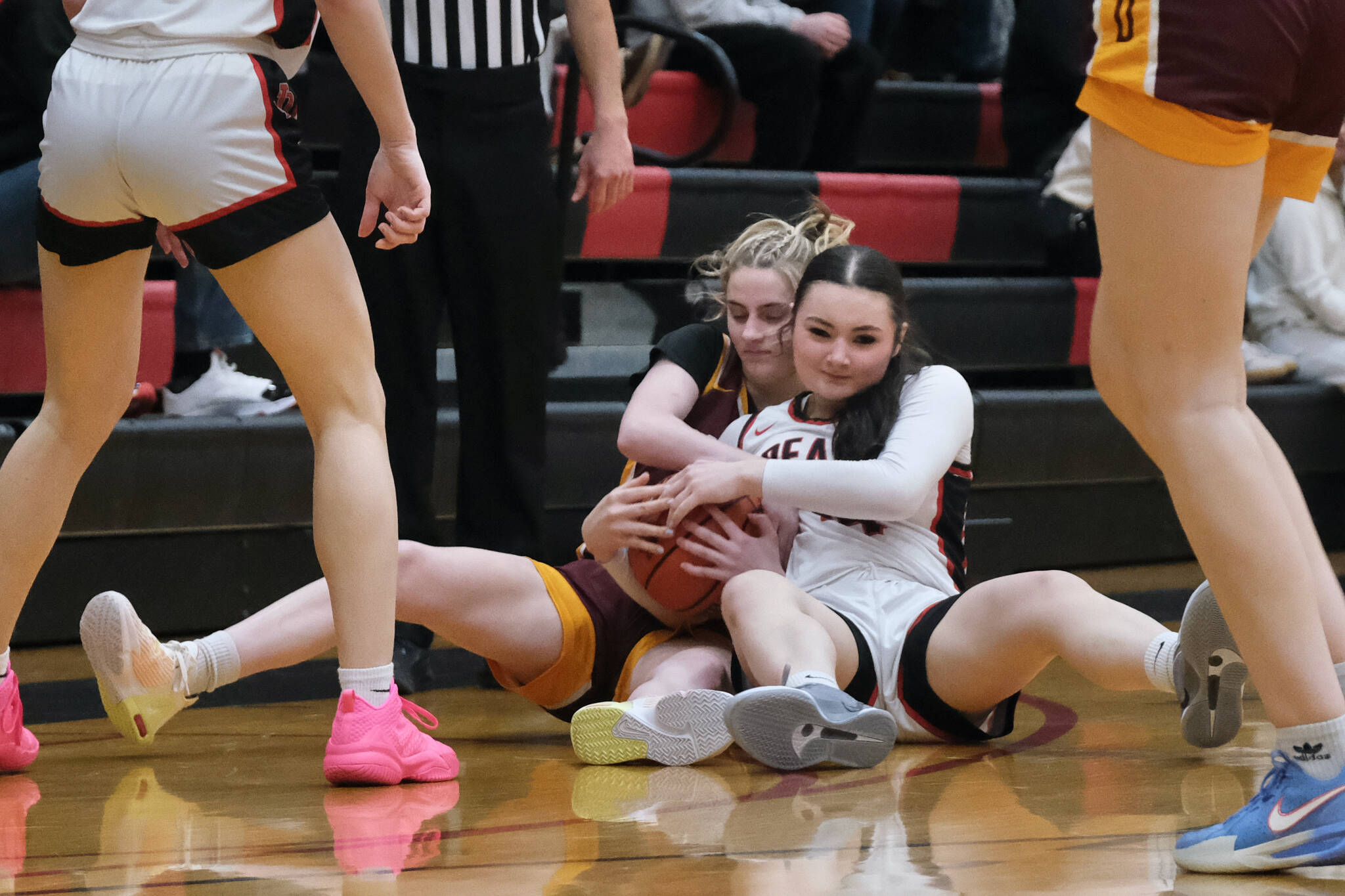 Dimond junior Katie MacDonald and Juneau-Douglas High School: Yadaa.at Kalé sophomore Layla Tokuoka battle for a ball during Friday’s Crimson Bears 62-48 win over the Lynx inside the George Houston Gymnasium. The teams play Saturday at 7 p.m. (Klas Stolpe / Juneau Empire)