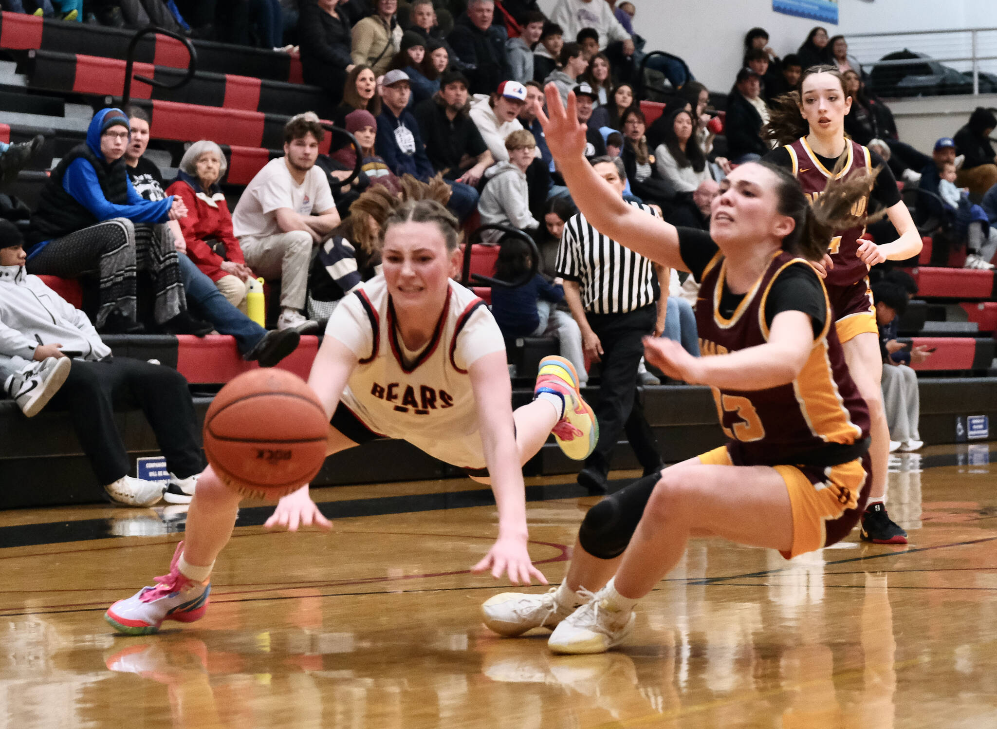 Juneau-Douglas High School: Yadaa.at Kalé junior Gwen Nizich (11) and Dimond senior Sienna Pederson (23) dive for a ball during Friday’s Crimson Bears 62-48 win over the Lynx inside the George Houston Gymnasium. The teams play Saturday at 7 p.m. (Klas Stolpe / Juneau Empire)