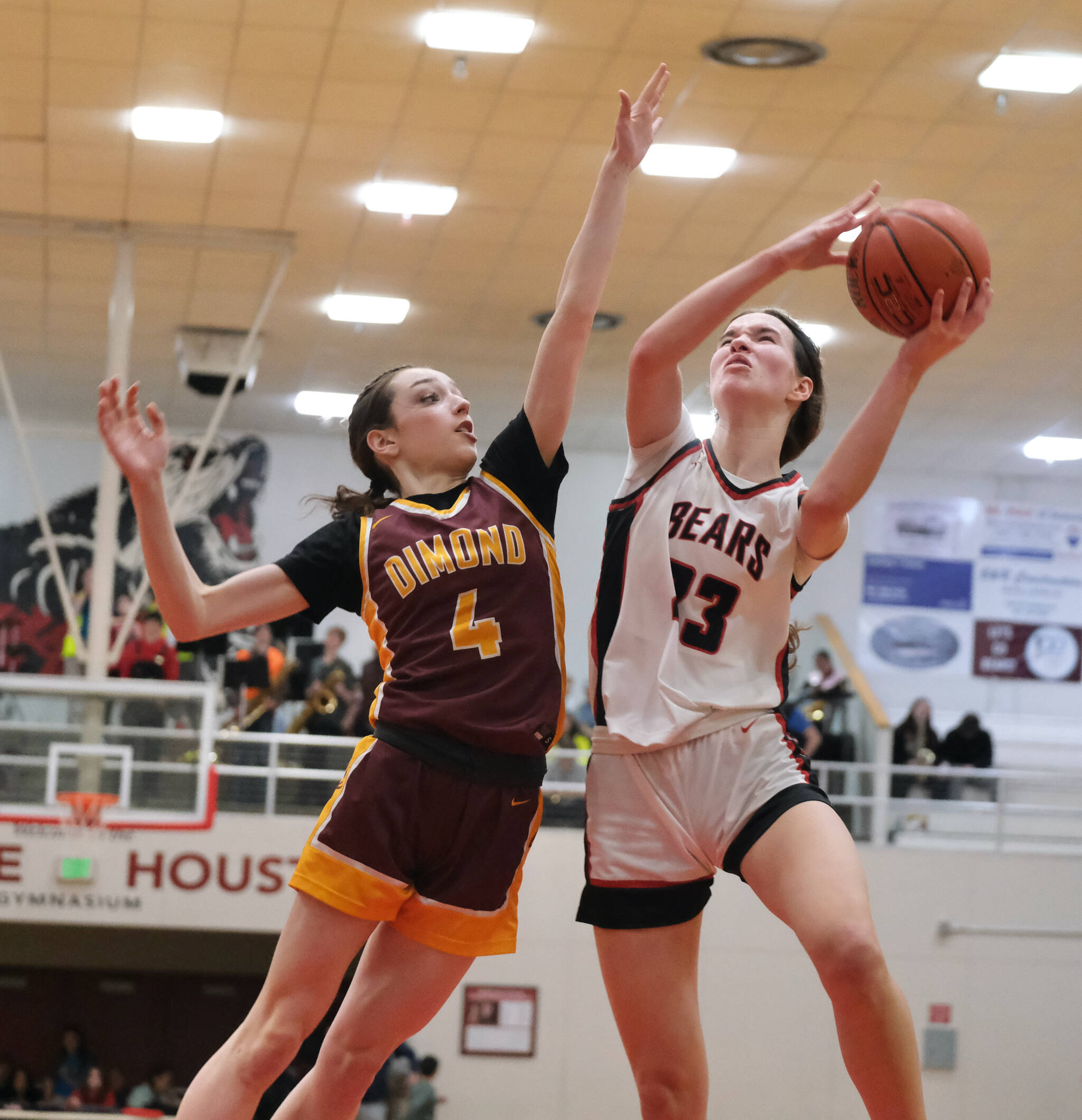 Dimond junior Sophie Scott (4) defends a shot by Juneau-Douglas High School: Yadaa.at Kalé senior Cailynn Baxter (23) during Friday’s JDHS Crimson Bears 62-48 win over the visiting Lynx inside the George Houston Gymnasium. The teams play Saturday at 7 p.m. (Klas Stolpe / Juneau Empire)