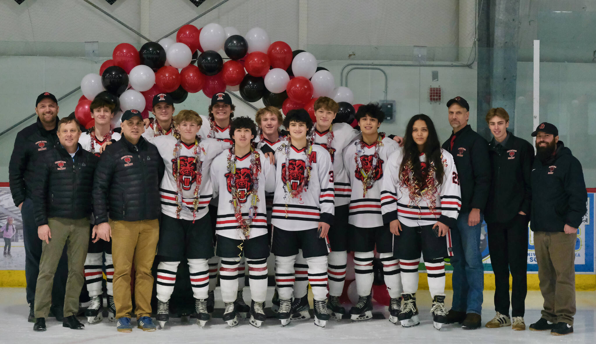 The Juneau-Douglas High School: Yadaa.at Kalé Crimson Bears seniors and coaches pose for a photo before their game Friday against the visiting Kenai Kardinals at Treadwell Ice Arena. (Klas Stolpe / Juneau Empire)