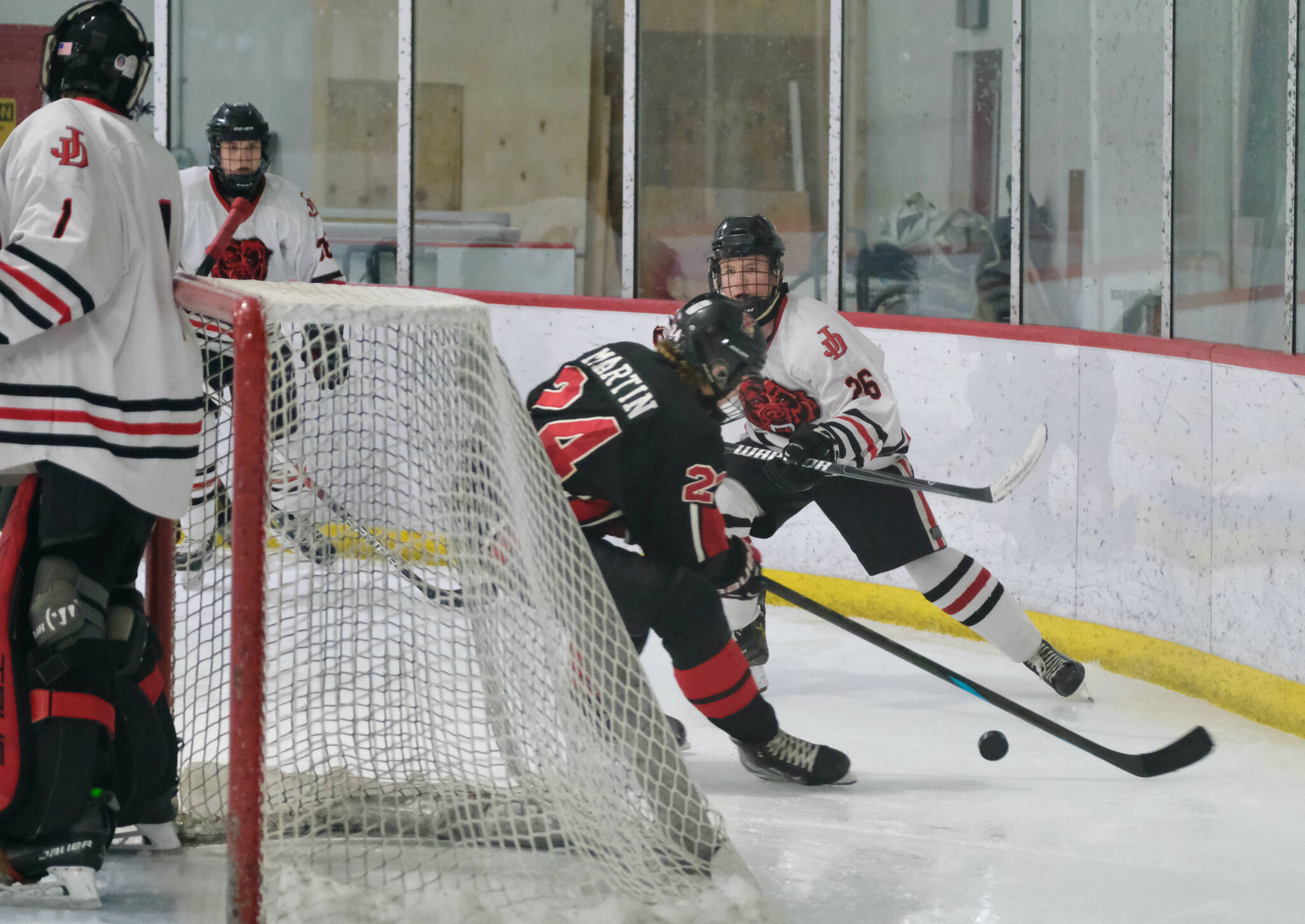 Juneau-Douglas High School: Yadaa.at Kalé senior Loren Platt (26) defends Kenai’s Avery Martin (24) during the Crimson Bears’ 5-1 loss to the Kardinals Saturday at Treadwell Ice Arena. (Klas Stolpe / Juneau Empire)