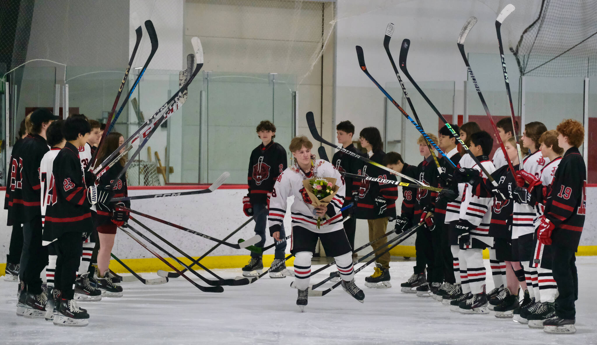 Juneau-Douglas High School: Yadaa.at Kalé senior Zander Smith skates onto the ice during ceremonies before the Crimson Bears’ game Friday against the visiting Kenai Kardinals at Treadwell Ice Arena. (Klas Stolpe / Juneau Empire)