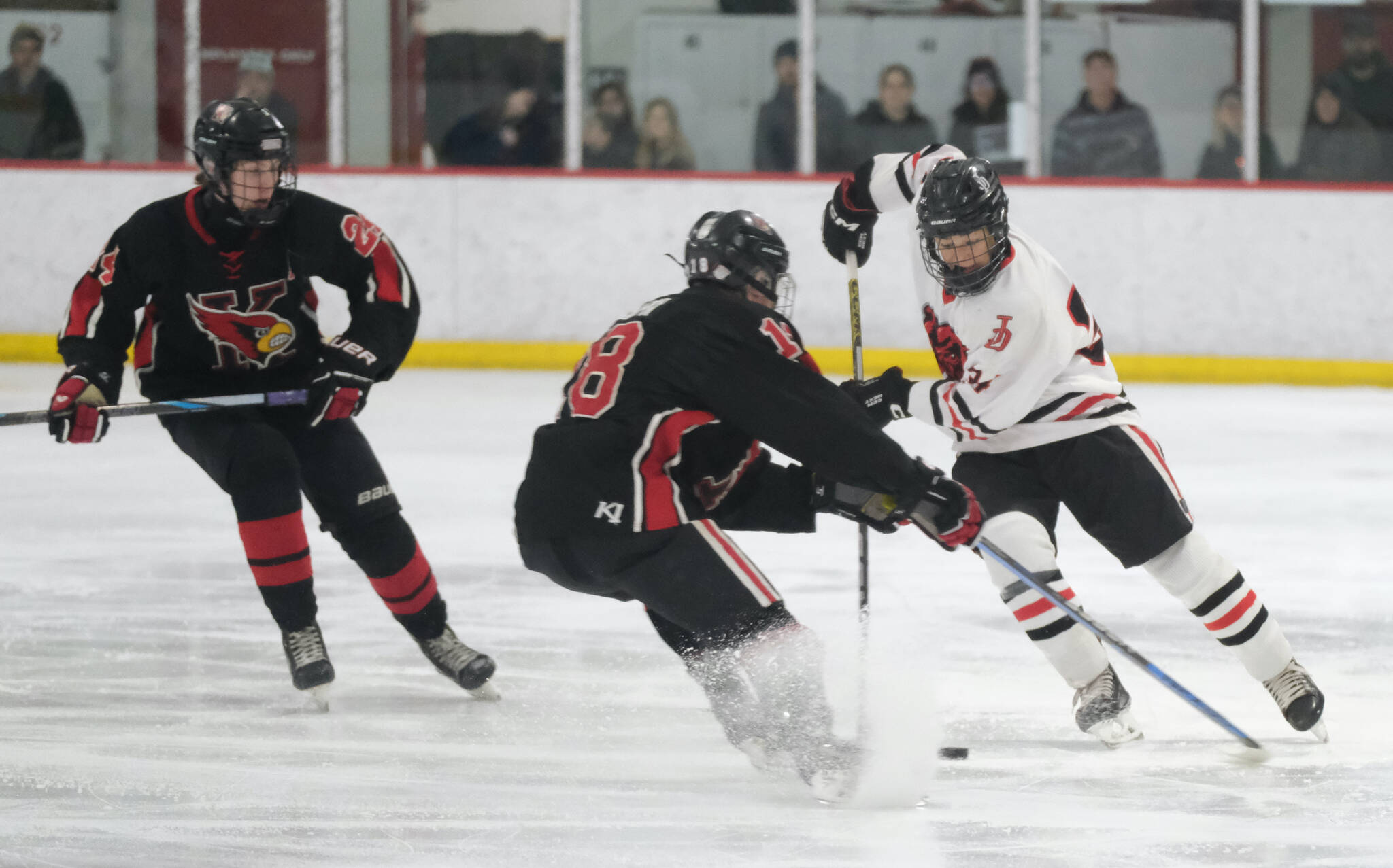 Juneau-Douglas High School: Yadaa.at Kalé sophomore Tricen Headings (34) moves a puck against Kenai’s Sawyer Vann (18) during the Crimson Bears’ 5-1 loss to the Kardinals on Saturday at Treadwell Ice Arena. (Klas Stolpe / Juneau Empire)