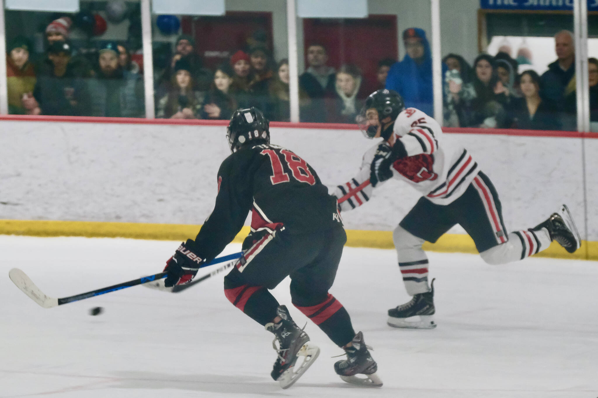 Juneau-Douglas High School: Yadaa.at Kalé senior Dylan Sowa (35) puts a shot past Kenai defender Sawyer Vann (18) during the Crimson Bears’ 5-4 loss to the Kardinals on Friday at Treadwell Ice Arena. The teams play Saturday at 8:30 a.m. (Klas Stolpe / Juneau Empire)