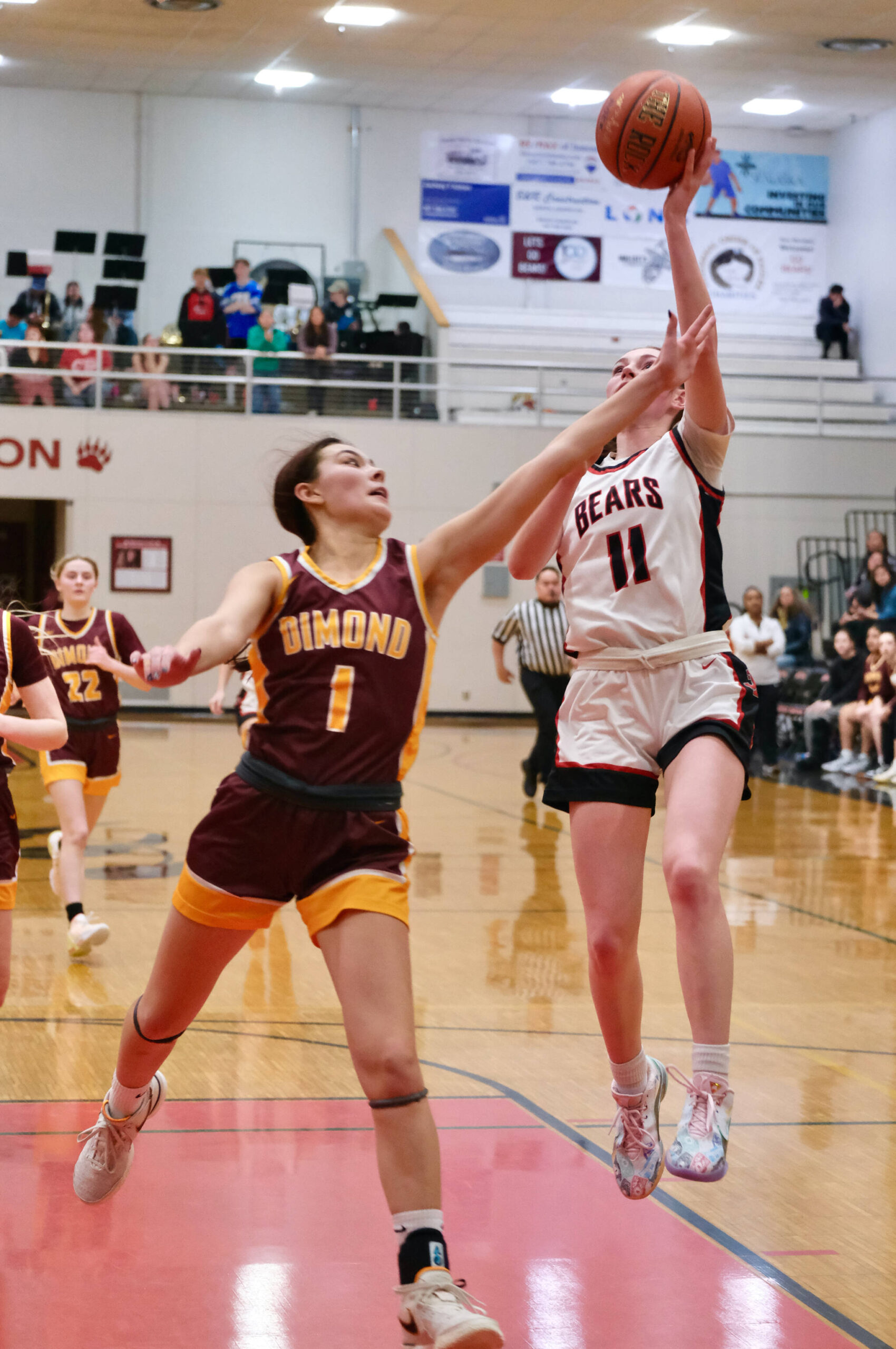 Dimond senior Mecca Goldsberry (1) defends a shot by Juneau-Douglas High School: Yadaa.at Kalé junior Gwen Nizich (11) during the Lynx’ 53-43 win Saturday over the Crimson Bears in the George Houston Gymnasium. (Klas Stolpe / Juneau Empire)