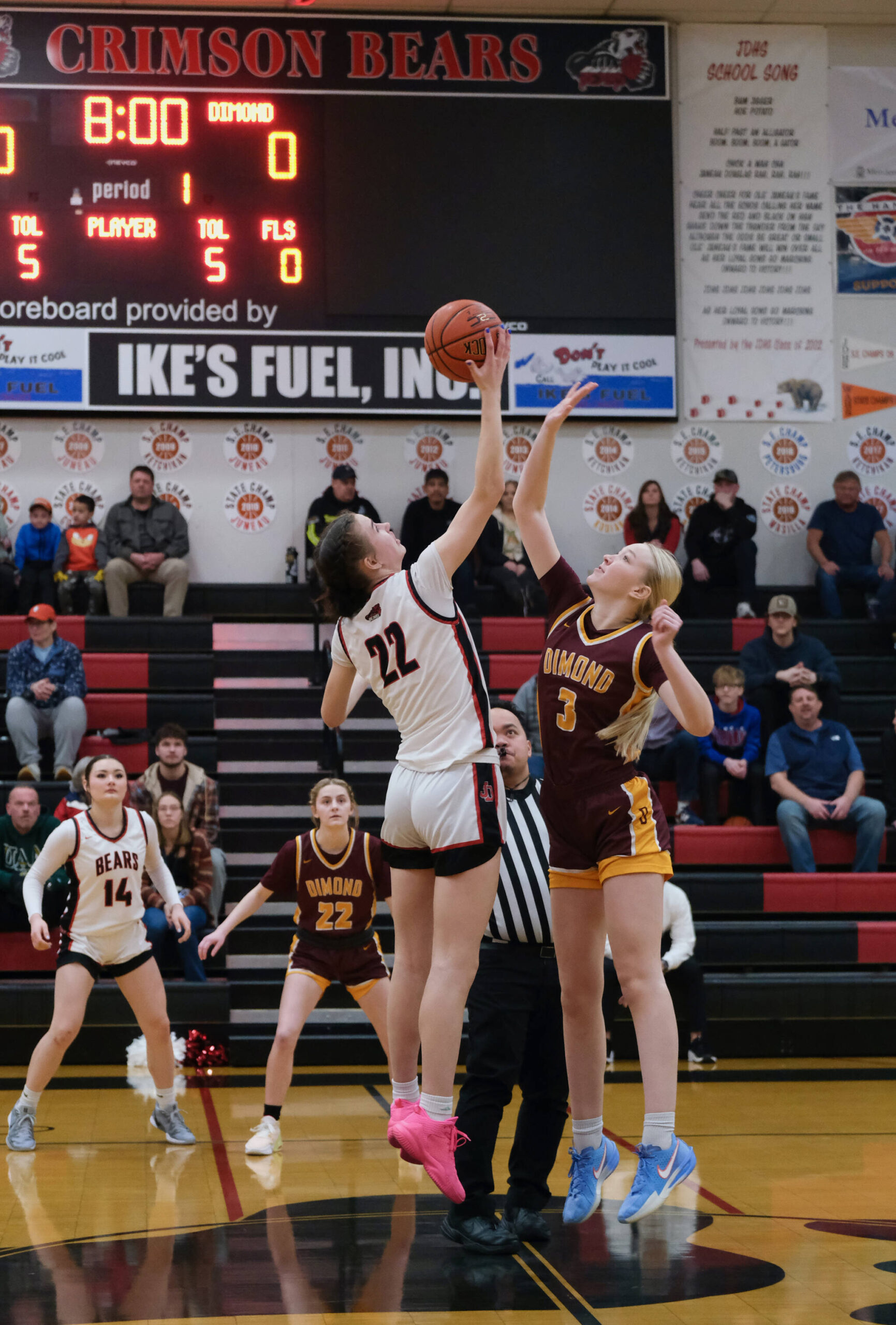 Juneau-Douglas High School: Yadaa.at Kalé senior Kerra Baxter (22) and Dimond senior Evan Hamey (3) tip off Saturday’s game in the George Houston Gymnasium. (Klas Stolpe / Juneau Empire)