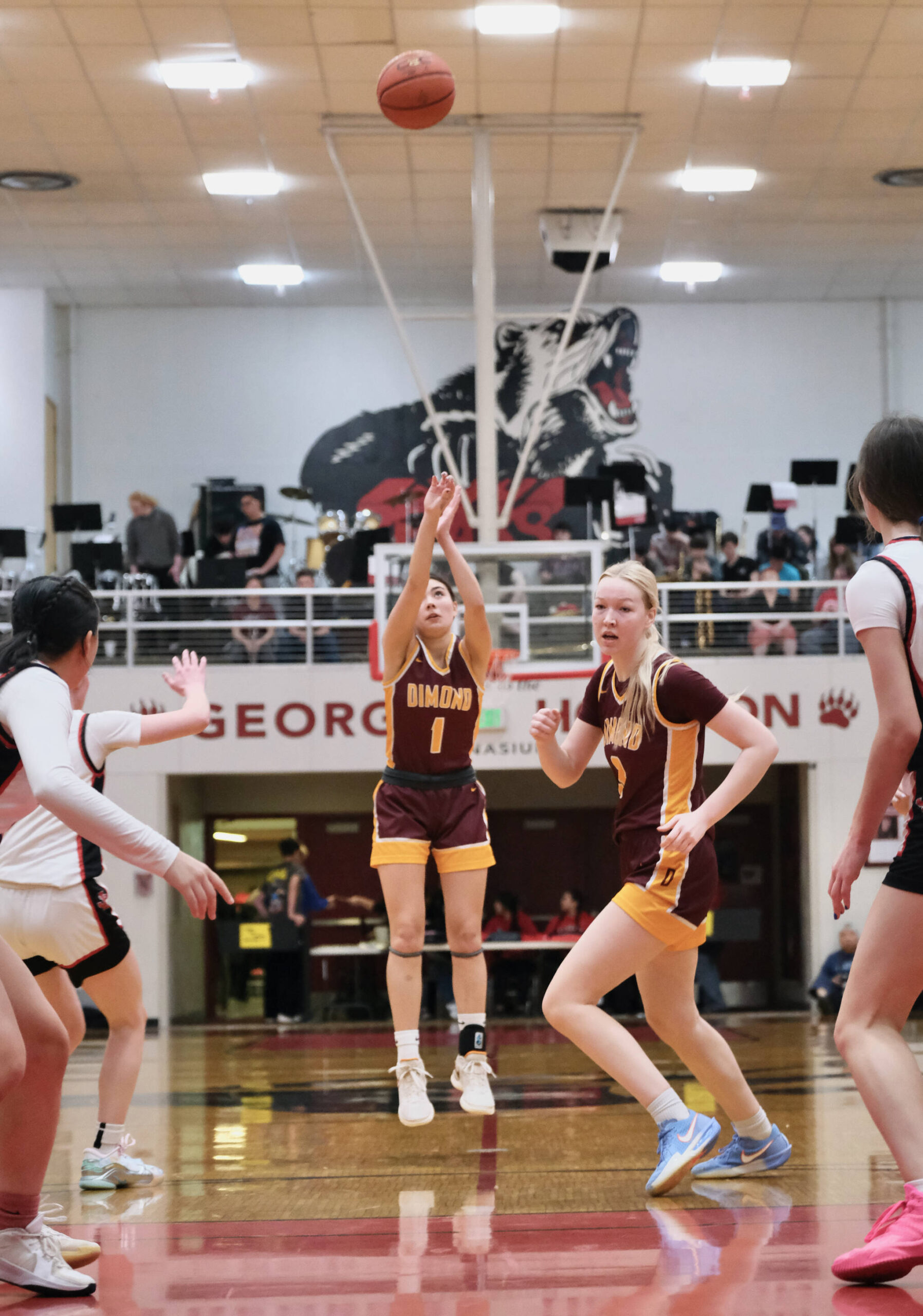 Dimond senior Mecca Goldsberry (1) shoots as senior Evan Hamey (3) moves to the basket during the Lynx’ 53-43 win over the Juneau-Douglas High School: Yadaa.at Kalé Crimson Bears on Saturday in the George Houston Gymnasium. (Klas Stolpe / Juneau Empire)