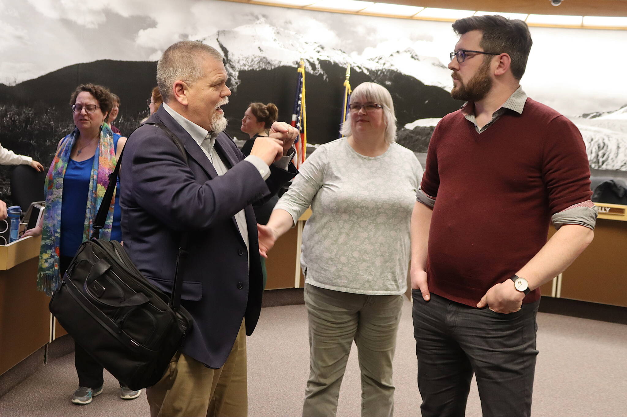 Mike Satre (left), chair of Eaglecrest Ski Area’s board of directors, talks about the resort’s plans with Mayor Beth Weldon and Juneau Assembly Member Neil Steininger following an Assembly Committee of the Whole meeting on Monday night at City Hall. (Mark Sabbatini / Juneau Empire)