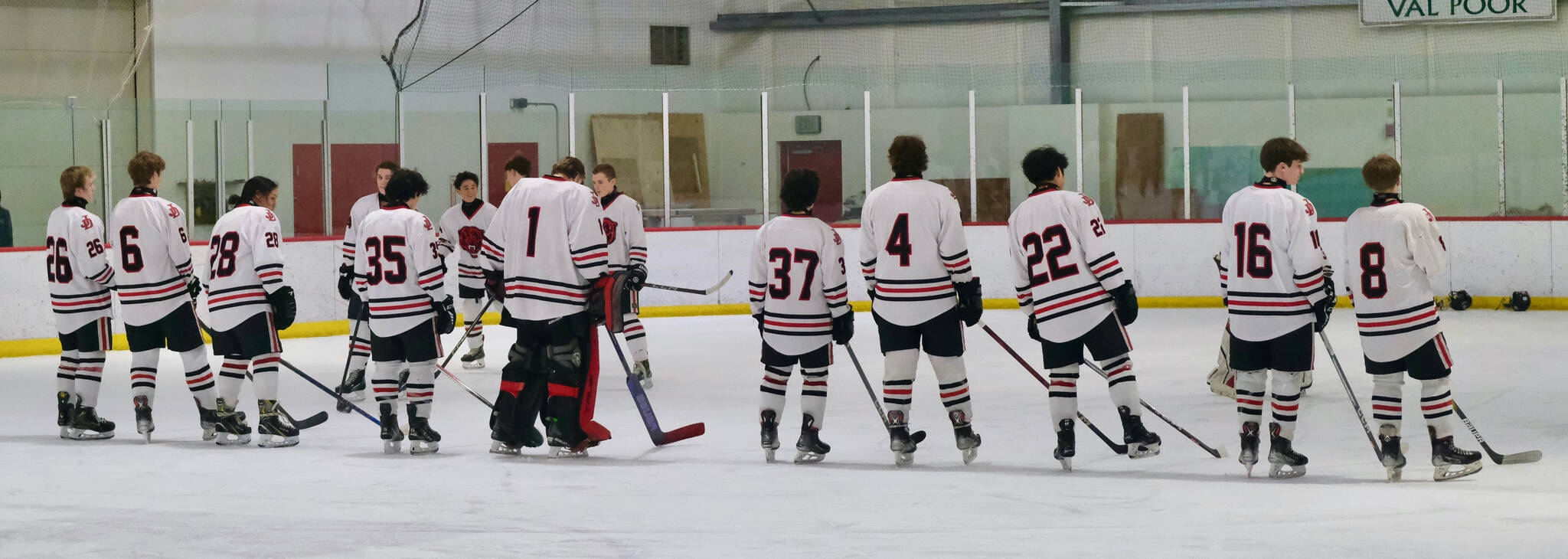 The Juneau-Douglas High School: Yadaa.at Kalé senior hockey players await the national anthem last week. (Klas Stolpe / Juneau Empire)