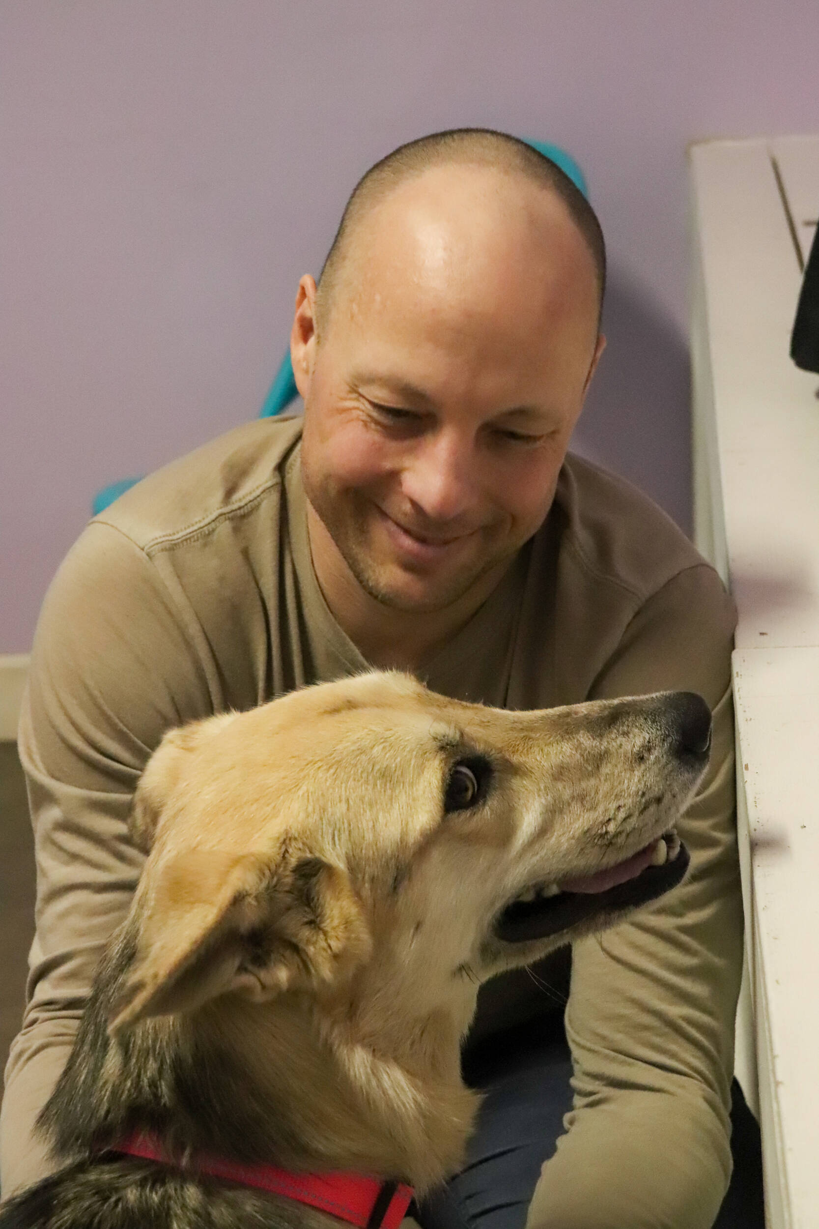 Thom Young and Pepper spend time together at the Juneau Animal Rescue dog visiting room on Jan. 28, 2025. (Jasz Garrett / Juneau Empire)