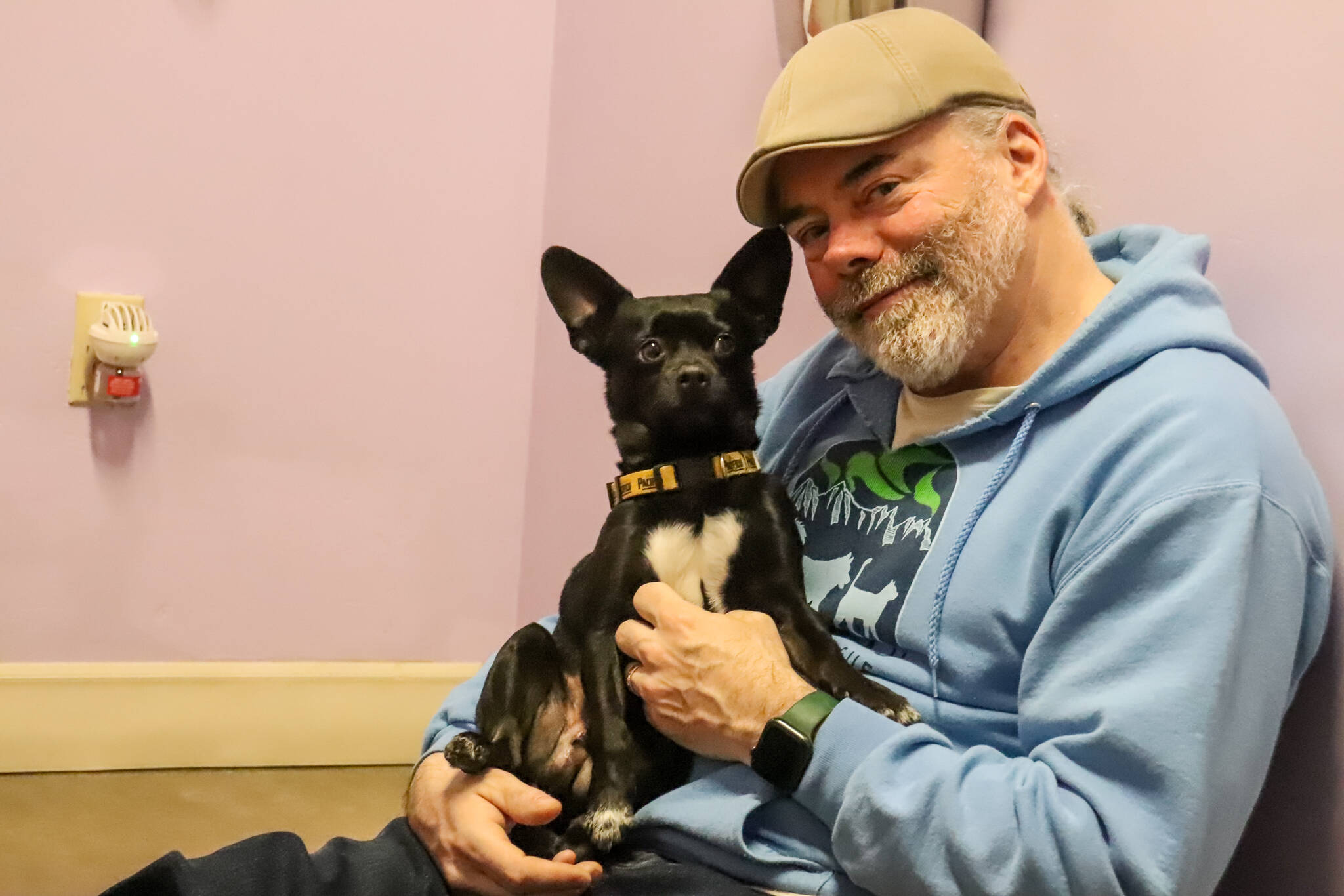 Rick Driscoll, executive director of Juneau Animal Rescue, spends time with Homer in a dog visiting room on Jan. 28, 2025. (Jasz Garrett / Juneau Empire)