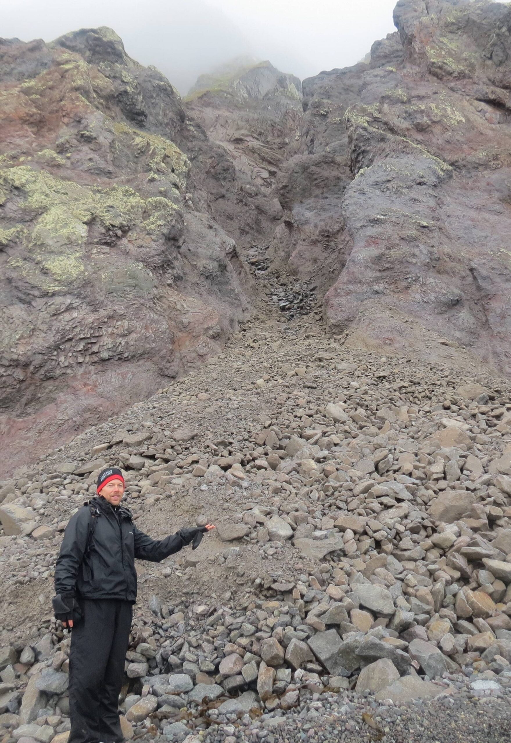 Ned Rozell pauses at the site of a rock avalanche on St. Matthew Island in the Bering Sea during a 2012 visit. (Photo by Rich Kleinleder)