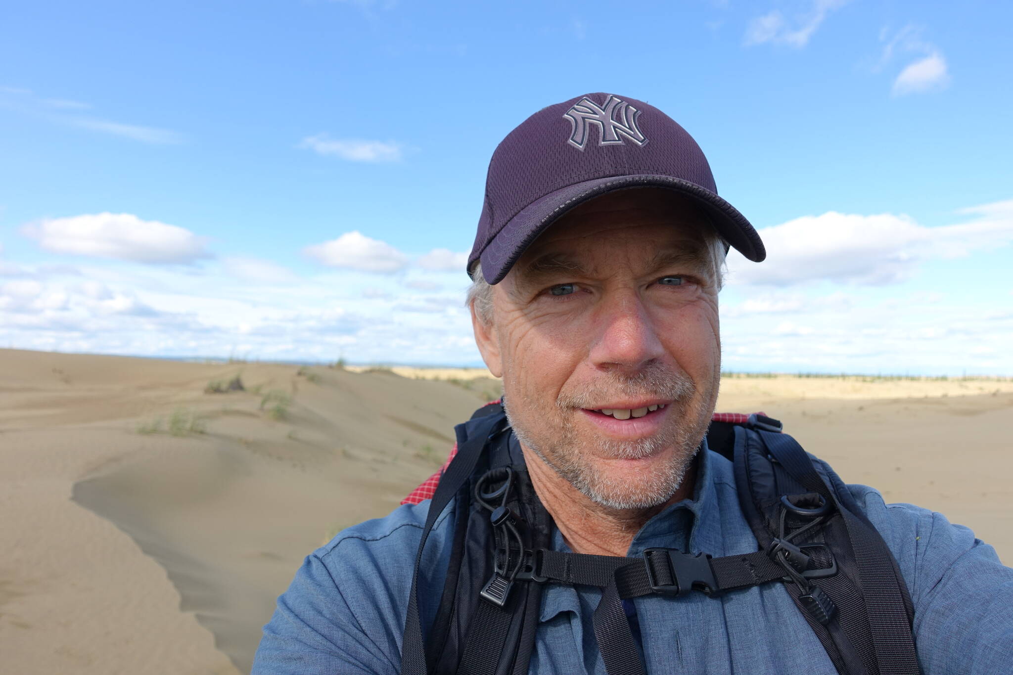 Ned Rozell hikes a sandy ridge at western Alaska’s Nogahabara Dunes in summer 2024. (Photo by Ned Rozell)