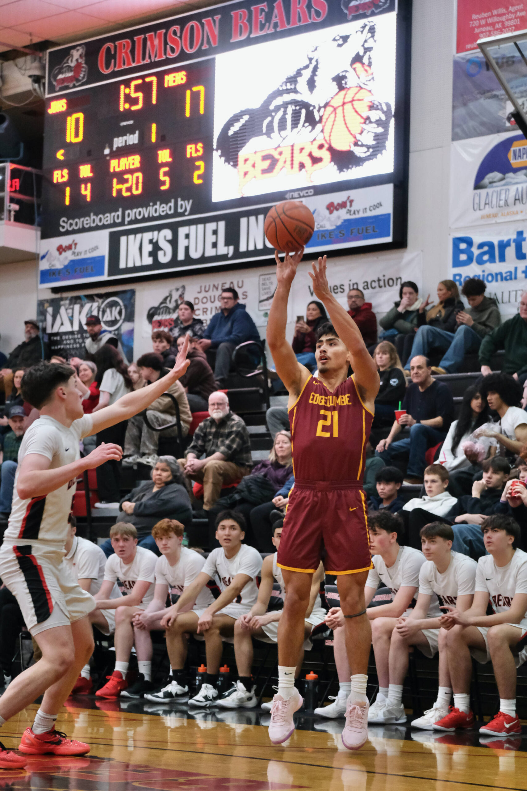 Mt. Edgecumbe senior Richard Didrickson Jr. (21) shoots over Juneau-Douglas High School: Yadaa.at Kalé junior Brandon Casperson (5) during the Braves 80-66 win over the Crimson Bears on Friday in the George Houston Gymnasium. The two teams play again Saturday at 6 p.m. (Klas Stolpe / Juneau Empire)