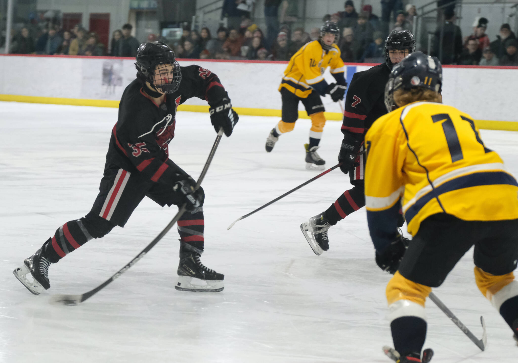 Juneau-Douglas High School: Yadaa.at Kalé senior Dylan Sowa (35) shoots against Tri-Valley during the Crimson Bears’ 4-2 loss to the Warriors at Treadwell Ice Arena on Saturday. (Klas Stolpe / Juneau Empire)