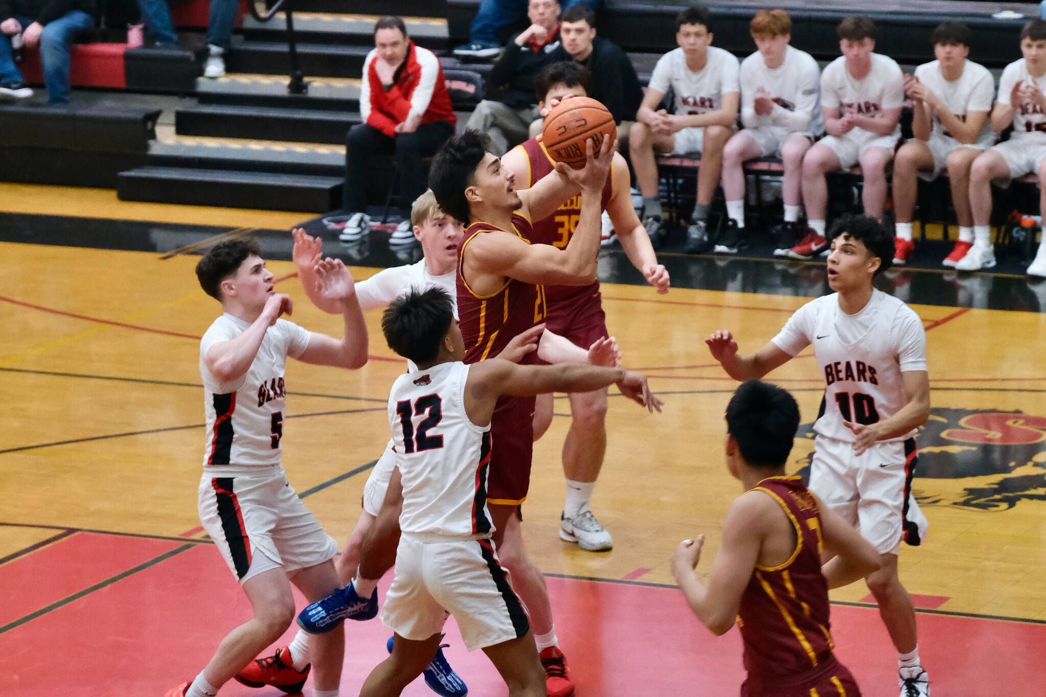 Mt. Edgecumbe senior RJ Didrickson (21) shoots against Juneau-Douglas High School: Yadaa.at Kalé juniors Brandon Casperson (5), Joren Gasga (12) and seniors Ben Sikes and Pedrin Saceda-Hurt (10) during the Braves’ 68-47 win over the Crimson Bears on Saturday in the George Houston Gymnasium. (Klas Stolpe / Juneau Empire)