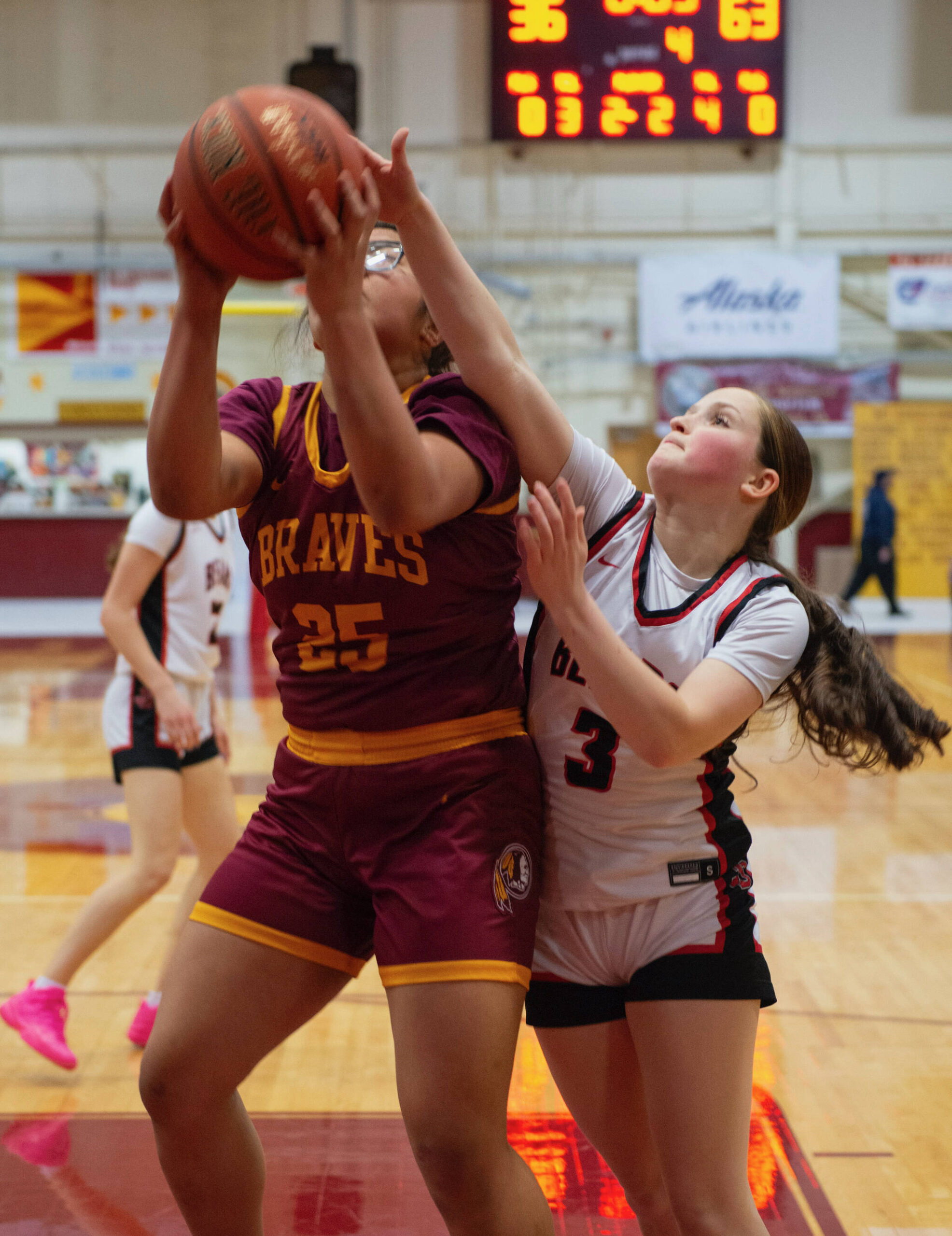 Mount Edgecumbe HIgh School’s Charity Mila (25), a sophomore from Barrow, shoots against strong defense from Juneau-Douglas High School: Yadaa.at Kalé junior Cambry Lockhart (3) Saturday at the B.J. McGillis Gym. (James Poulson / Daily Sitka Sentinel)