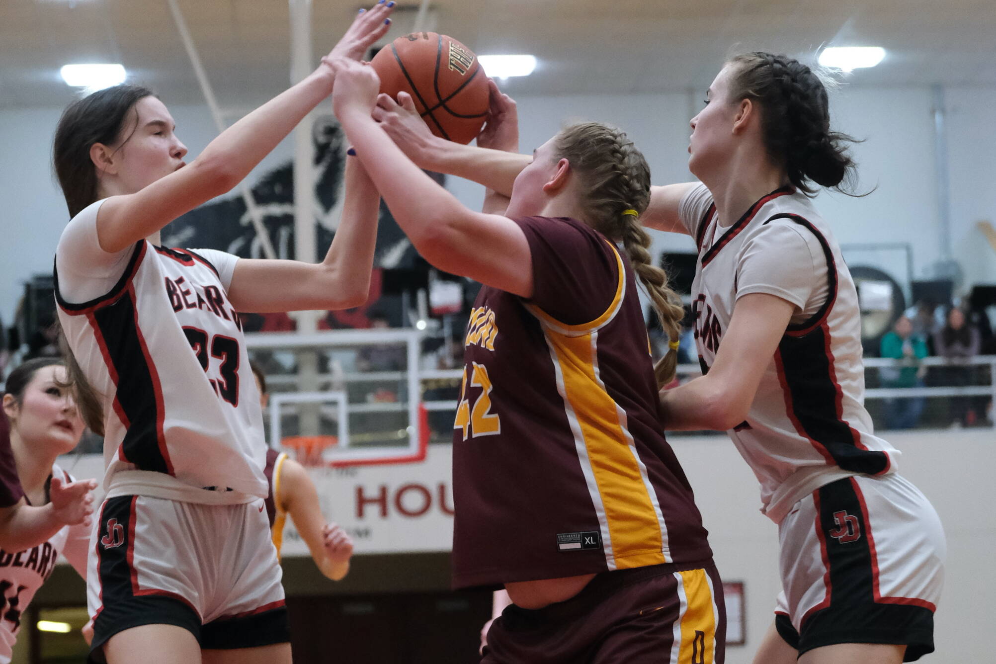 In this file photo Juneau-Douglas High School: Yadaa.at Kalé seniors Cailynn, left, and Kerra Baxter, right, battle for a rebound against Dimond High School. The Baxters led JDHS in scoring this weekend at Mt. Edgecumbe with Cailynn hitting 23 on Friday and Kerra 28 on Saturday. (Klas Stolpe / Juneau Empire file photo)