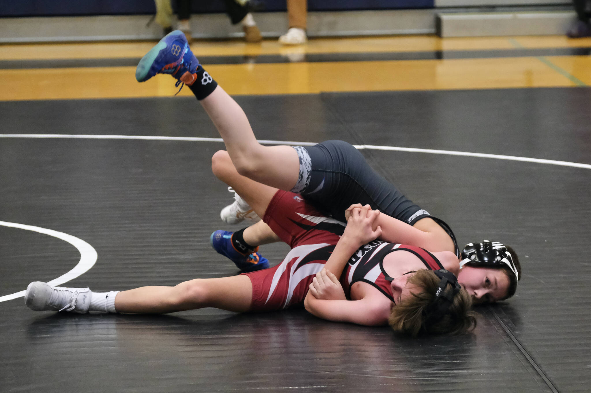 Thunder Mountain Middle School seventh grader Logan Sivertsen of Black Bear Legion steps over eighth grader Avery Nichols of Orange Crush to secure a pinning move during the inaugural Thunder Mountain Mayhem Team Duels wrestling tournament Saturday at TMMS. (Klas Stolpe / Juneau Empire)