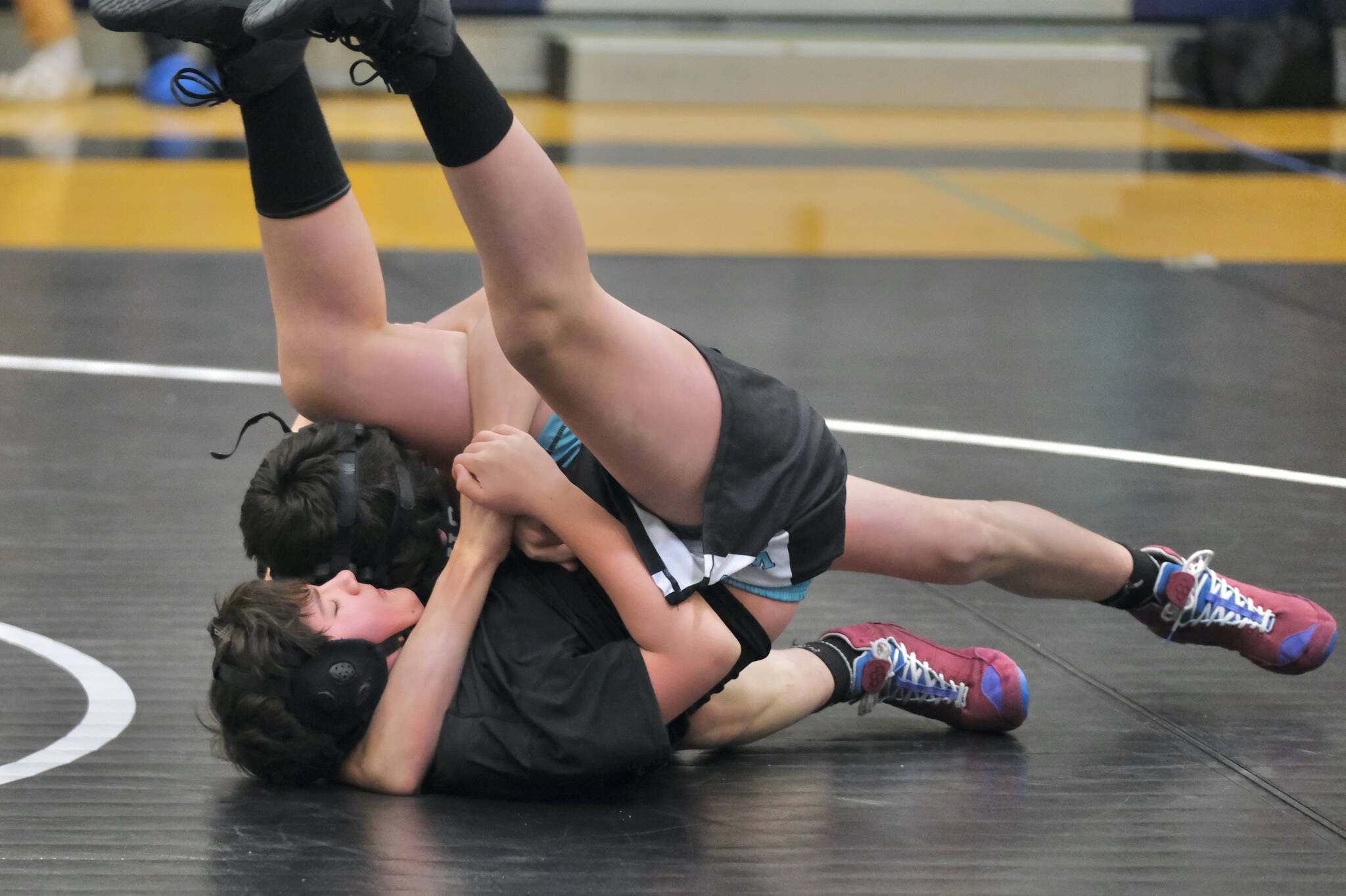 Thunder Mountain Middle School eighth grader Luke Darbonne of team Orange Crush uses a Crossface Cradle to pin Black Bear Legion’s Aero Ekerson during the inaugural Thunder Mountain Mayhem Team Duels wrestling tournament Saturday at TMMS. (Klas Stolpe / Juneau Empire)