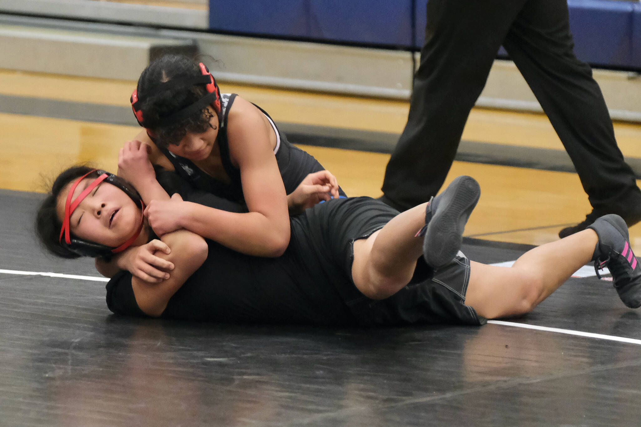 Blue Barracuda Bombers seventh grader Ngai Kivalu, top, and War Hawks White eighth grader Ciara Dutton during the inaugural Thunder Mountain Mayhem wrestling tournament Saturday at Thunder Mountain Middle School. (Klas Stolpe / Juneau Empire)