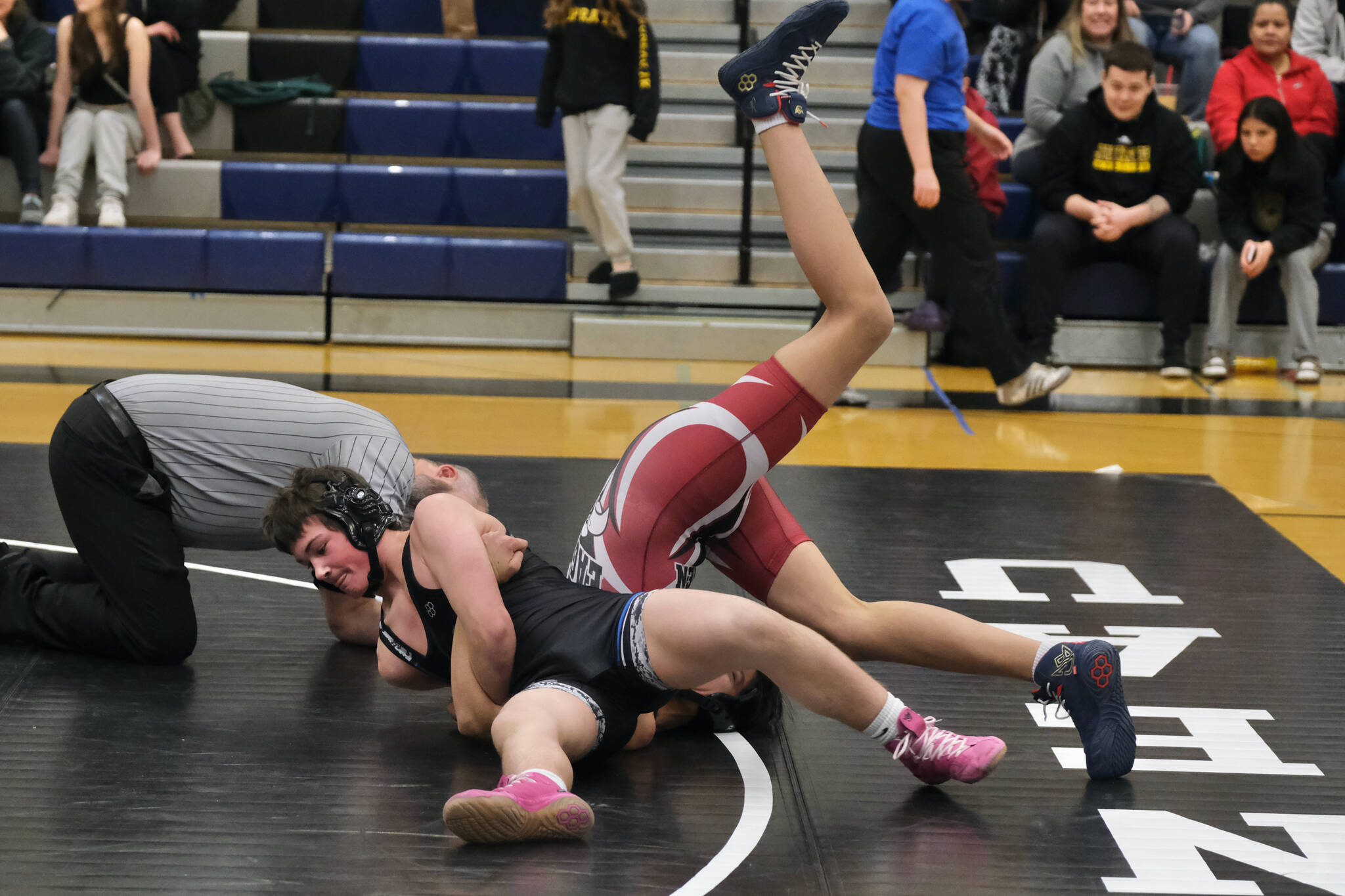 Thunder Mountain Middle School eighth grader Carter Day of the Blue Barracuda Bombers attempts to pin classmate John Croasman of War Hawks White during the inaugural Thunder Mountain Mayhem Team Duels wrestling tournament Saturday at TMMS. (Klas Stolpe / Juneau Empire)