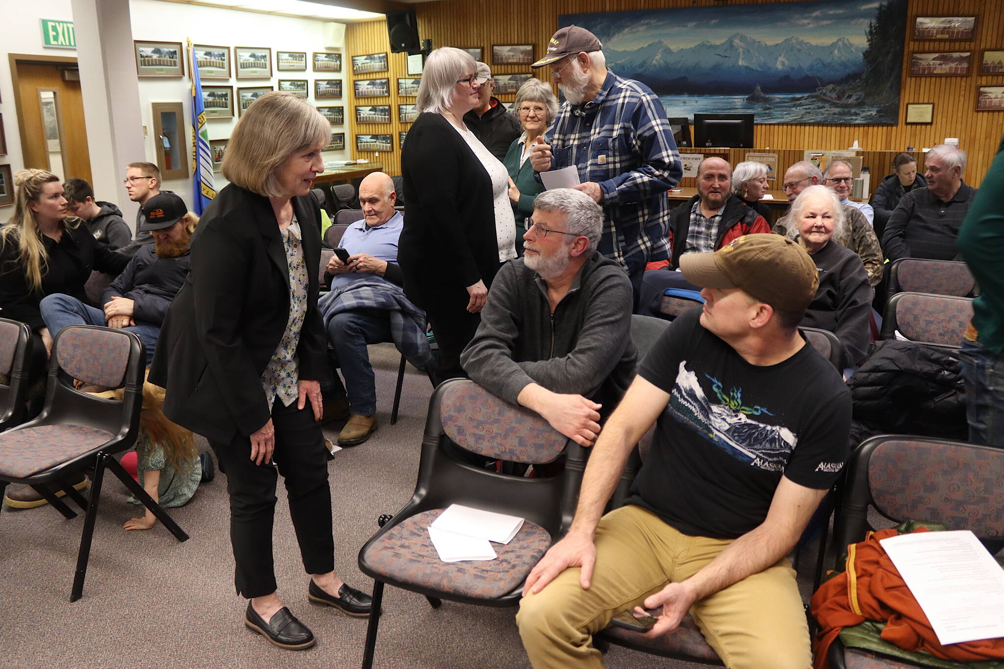 Juneau Assembly Member Maureen Hall (left) and Mayor Beth Weldon (center) talk to residents during a break in an Assembly meeting Monday, Feb. 3, 2025, about the establishment of a Local Improvement District that would require homeowners in the area to pay nearly $6,300 each for barriers to protect against glacial outburst floods. (Mark Sabbatini / Juneau Empire)