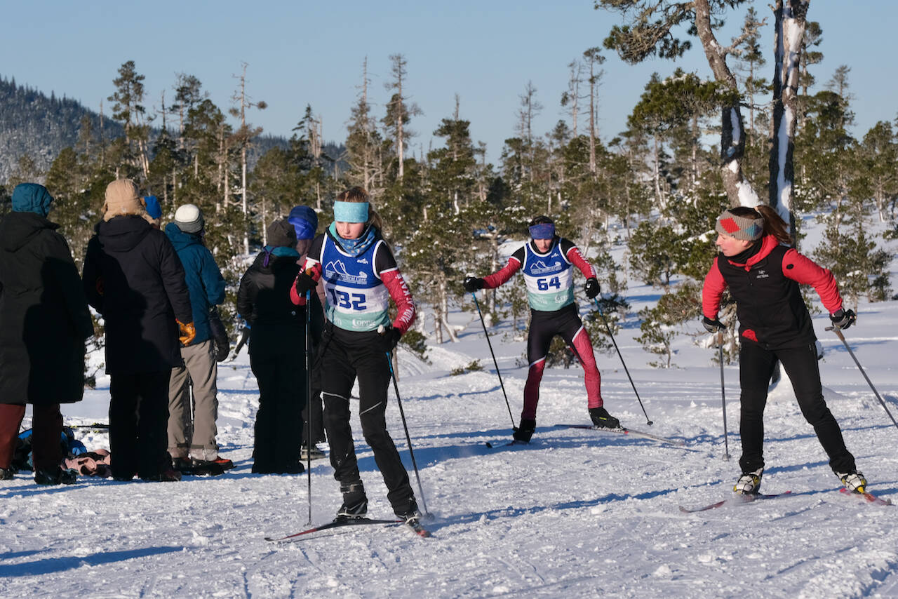 Juneau-Douglas High School: Yadaa.at Kalé Nordic Ski Team seniors Ida Meyer (132) and Finley Hightower (64) are encouraged by coach Abby McAllister during the Shaky Shakeout Invitational six-kilometer freestyle mass start Saturday at Eaglecrest Ski Area. (Klas Stolpe / Juneau Empire)