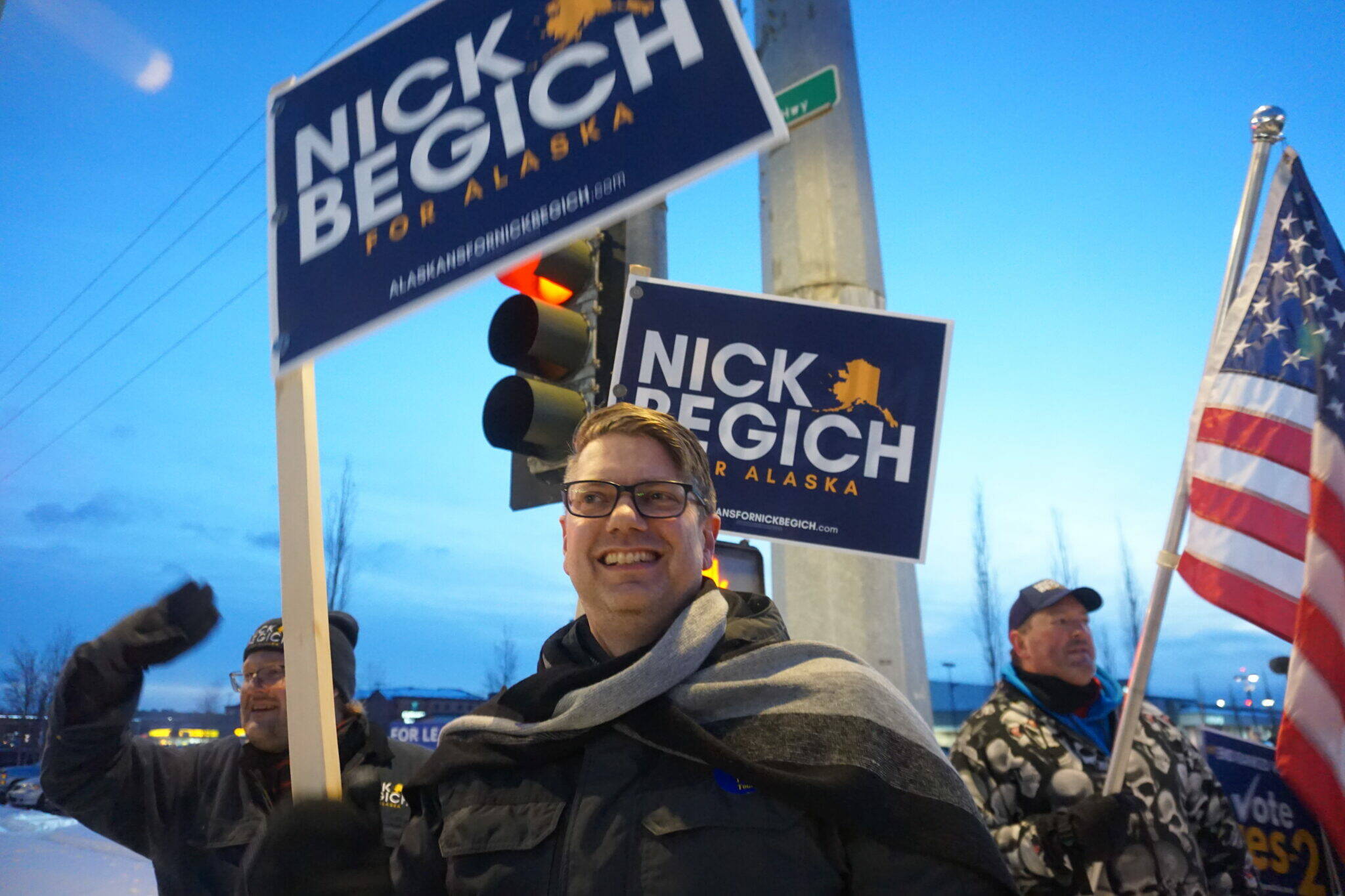 Republican U.S. House candidate Nick Begich and his supporters wave campaign signs at the corner of the Seward Highway and Northern Lights Boulevard on Nov. 4, 2024, the day before Election Day. (Yereth Rosen/Alaska Beacon)