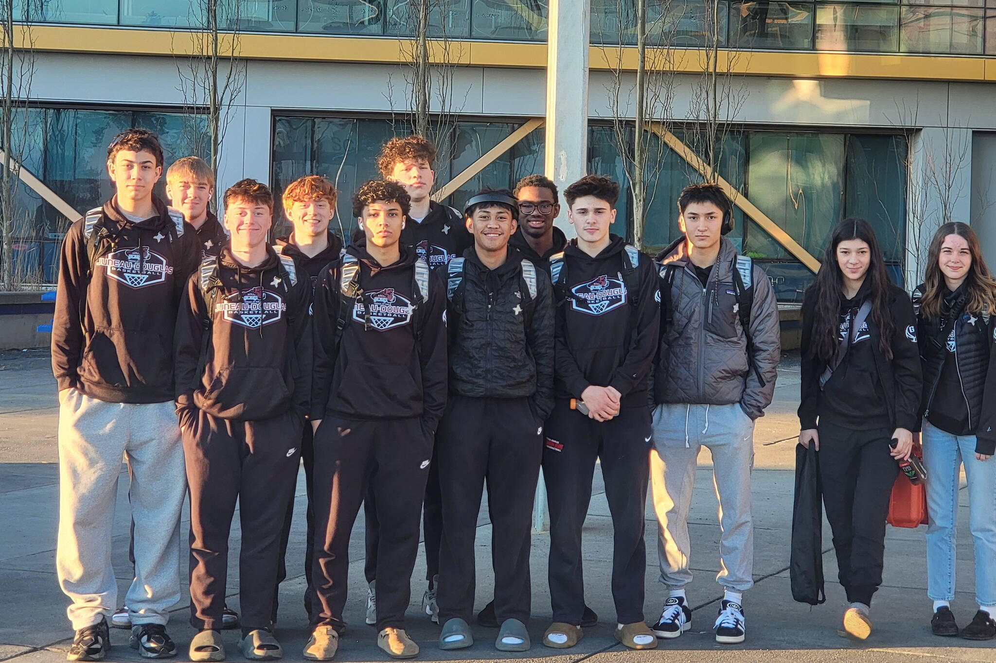 The Juneau-Douglas High School: Yadaa.at Kalé Crimson Bears boys basketball team pose outside Kodiak High School during their sweep over the Bears this weekend. (Photo courtesy JDHS)