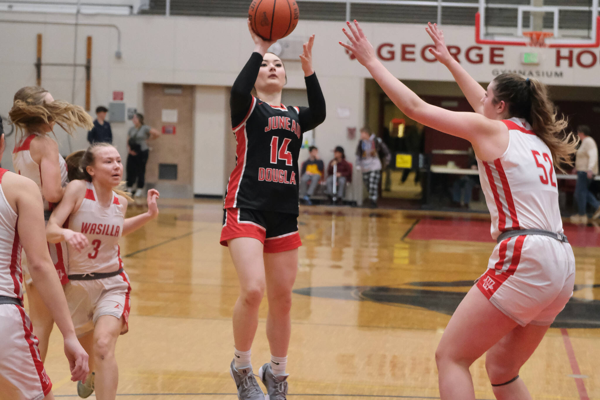 Juneau-Douglas High School: Yadaa.at Kalé sophomore Layla Tokuoka (14) floats a jump shot over Wasilla senior Layla Hays (52) during the Crimson Bears’ 46-30 loss Saturday to the Warriors in the George Houston Gymnasium. (Klas Stolpe / Juneau Empire)