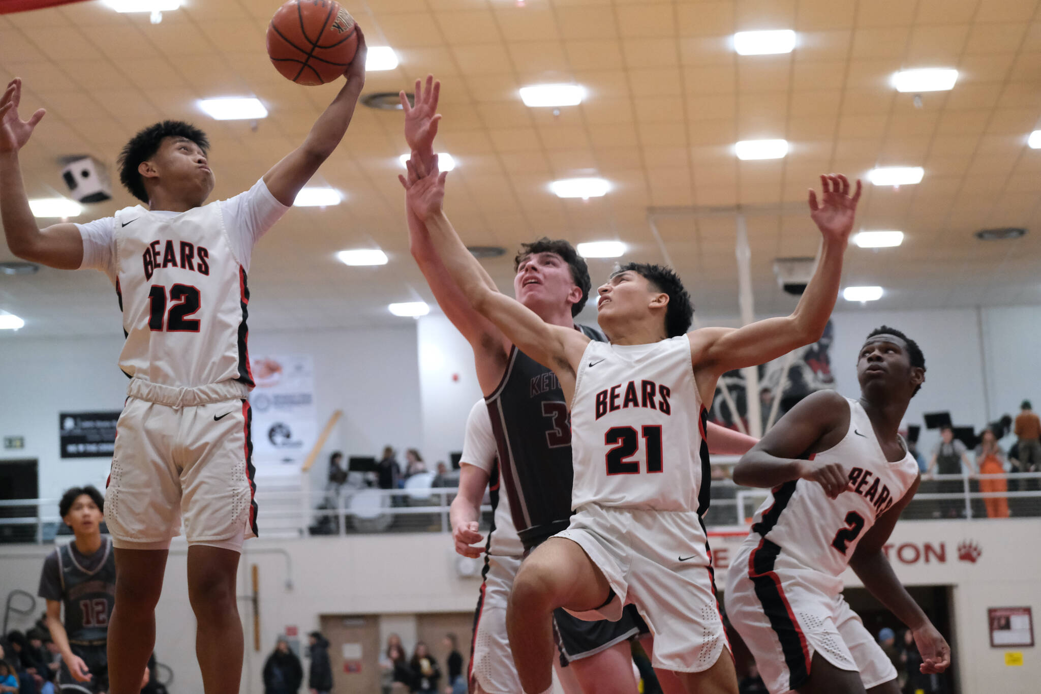 Juneau-Douglas High School: Yadaa.at Kalé junior Joren Gasga (12), junior Tyler Frisby (21) and senior Ahmir Parker (2) battle with Ketchikan senior Marcus Stockhausen for a rebound during their series early in the season at JDHS. (Klas Stolpe / Juneau Empire)