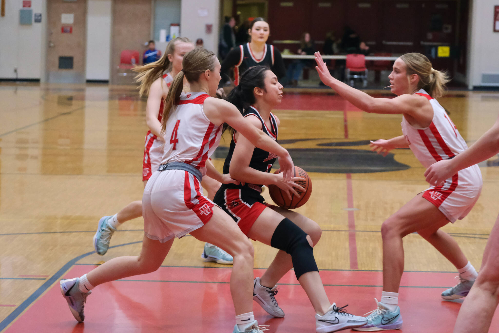 Juneau-Douglas High School: Yadaa.at Kalé senior Mary Johnson protects the ball from Wasilla junior Mielee Merchant (4) and senior Mylee Anderson (14) during a Crimson Bears loss to the Warriors last weekend in the George Houston Gymnasium. JDHS will host Ketchikan at 7 p.m. Thursday and Friday. (Klas Stolpe / Juneau Empire)