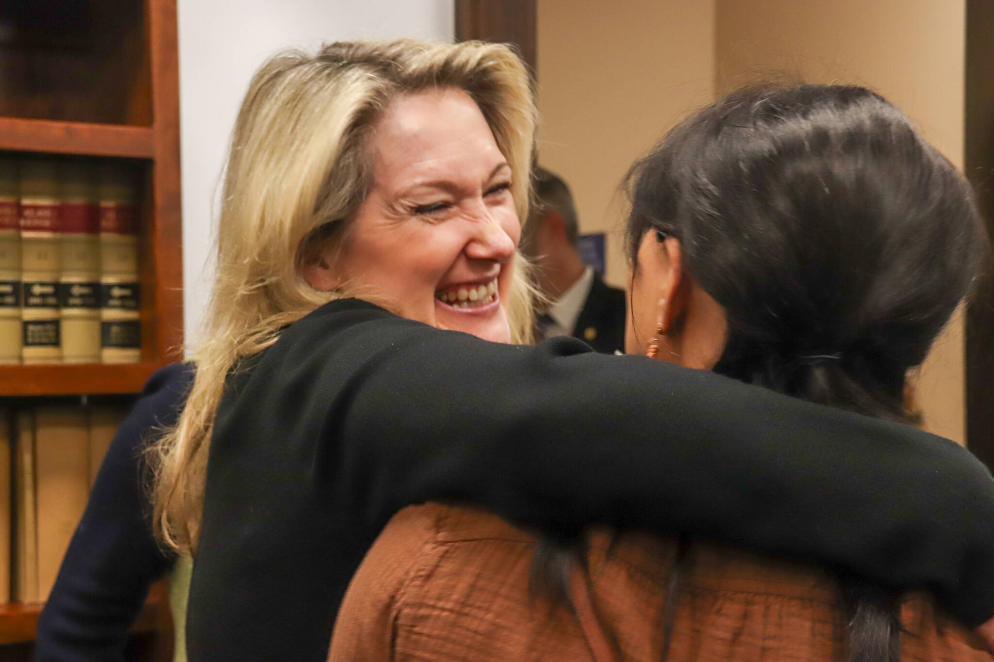 Tetyana Robbins, executive director of Project Alaska, embraces Deepika Ramesh Perumal, executive director of the Alaska Literacy Project, after a House Judiciary Committee meeting at the Alaska State Capitol Building on Feb. 19, 2025. The presentation to the Alaska Legislature was one of many in Juneau this week by immigration leaders in the state. (Jasz Garrett / Juneau Empire)