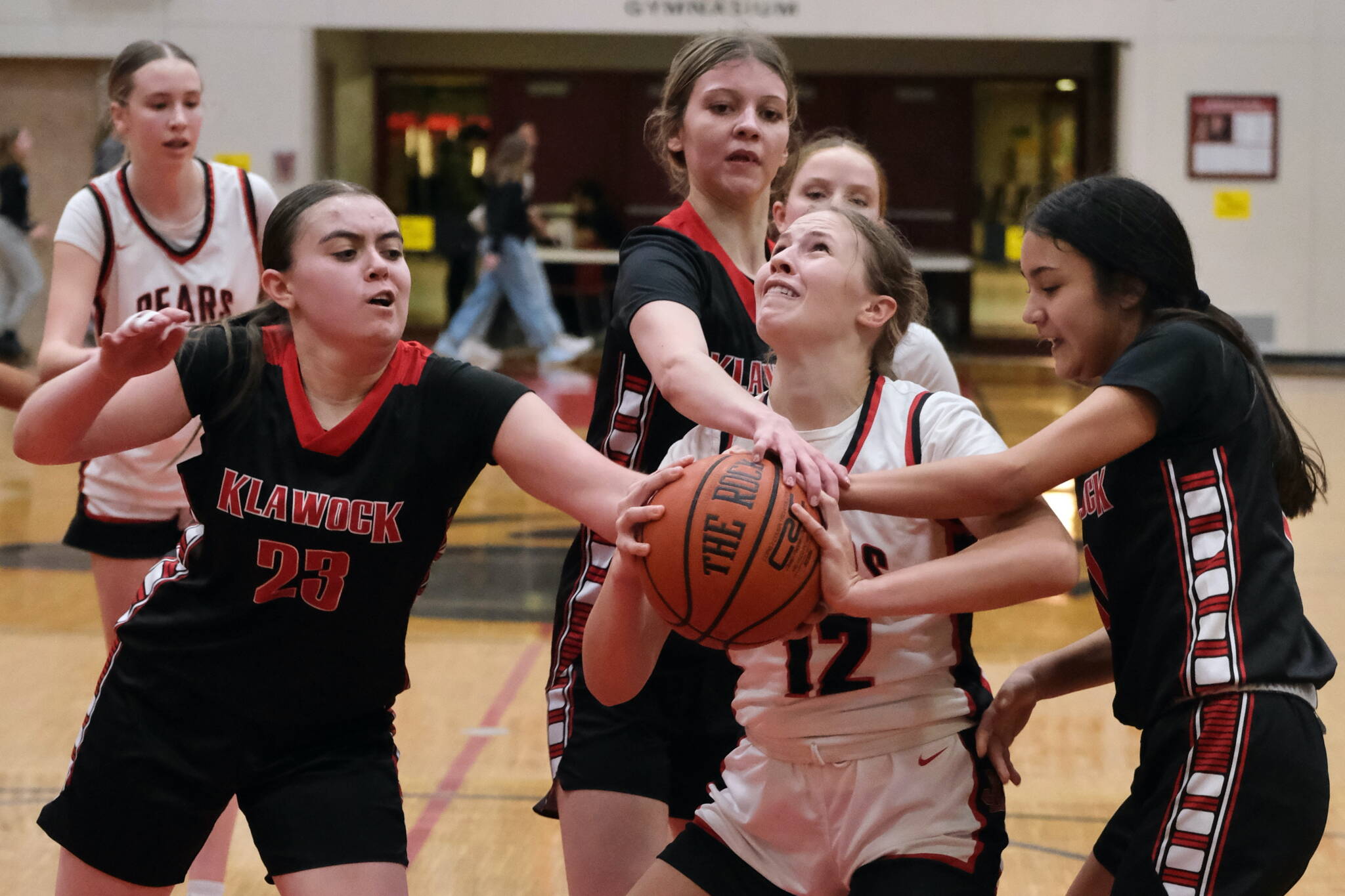 This file photo shows Klawock senior Lea Armour (23), eighth grader Jayla Edenshaw and senior Kaiya Marvin defending Juneau-Douglas High School: Yadaa.at Kalé sophomore Bergen Erickson (12) during this season's Capital City Classic in the George Houston Gymnasium. The Region V 1A basketball championships begin Wednesday at Thunder Mountain Middle School. (Klas Stolpe / Juneau Empire)